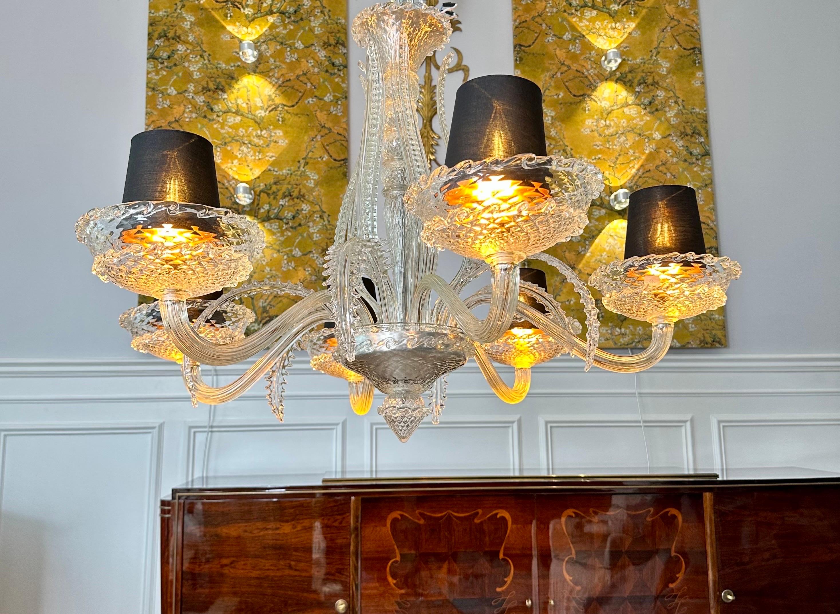 This translucent blown glass chandelier with 6 sconces dates from the late 1930s and early 1940s. It was produced by the Veronese house and Attributed to André Arbus. 
Morano glass and crystal. It is made up of 6 large sconces adorned with large