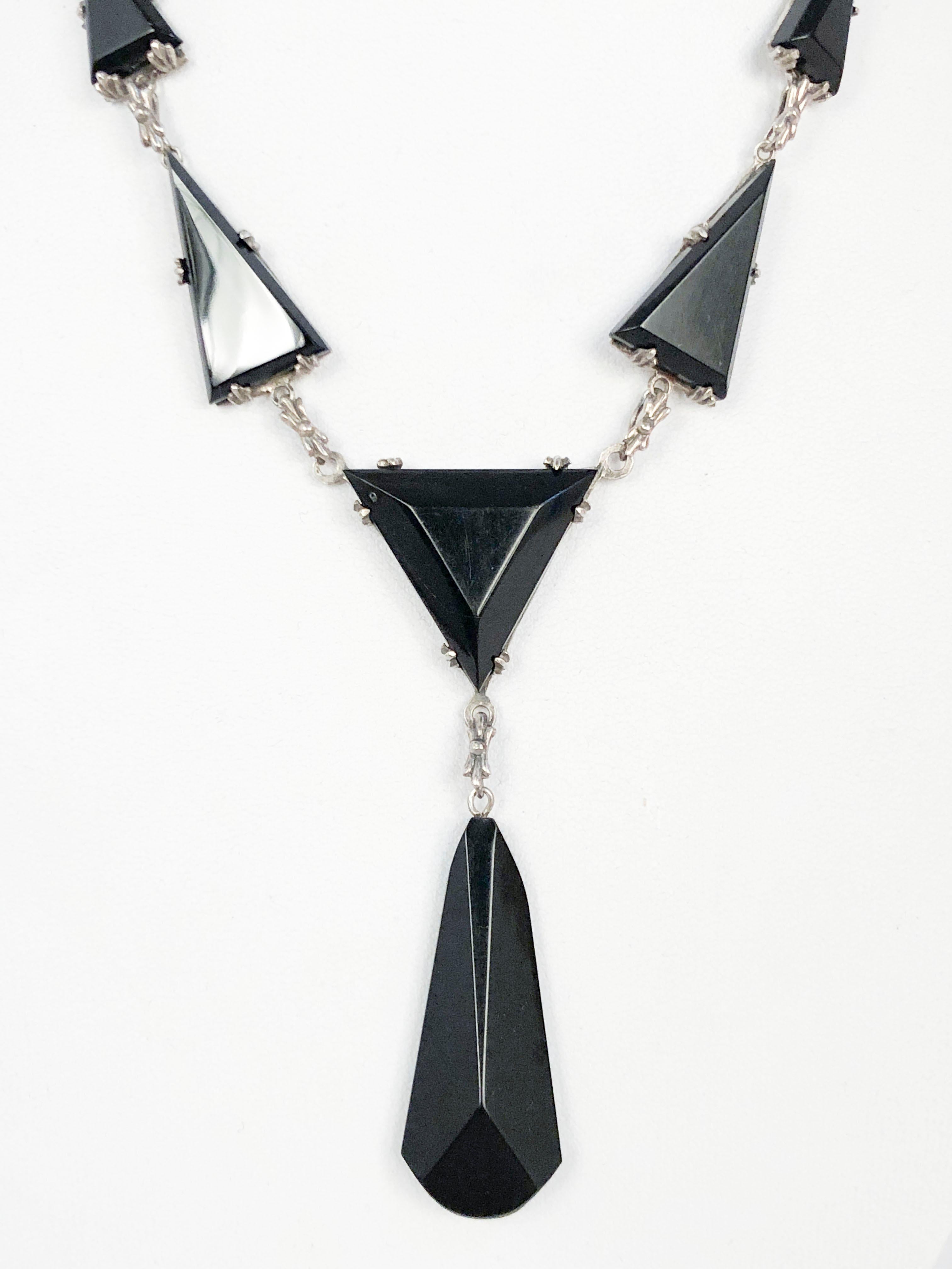1930s Art Deco Silver necklace featuring geometric shaped onyx and black bakelite, teardrop hanging accent and filigree closure. 
