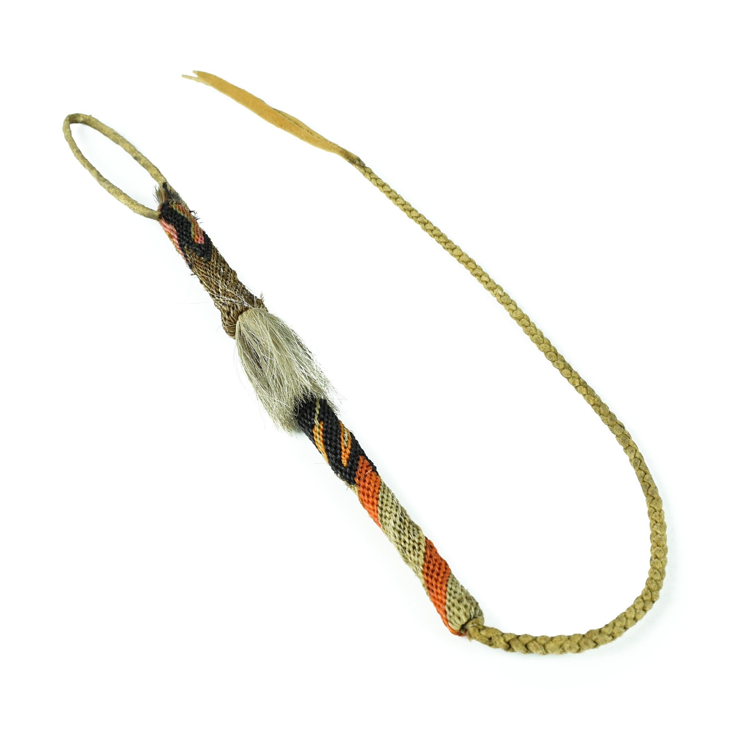 Deer Lodge Prison quirt with orange, black, and white dyed horsehair and leather hand strap and finely braided flapper. 
PERIOD: Early 20th Century
ORIGIN: Montana, United States
SIZE: Quirt: 12