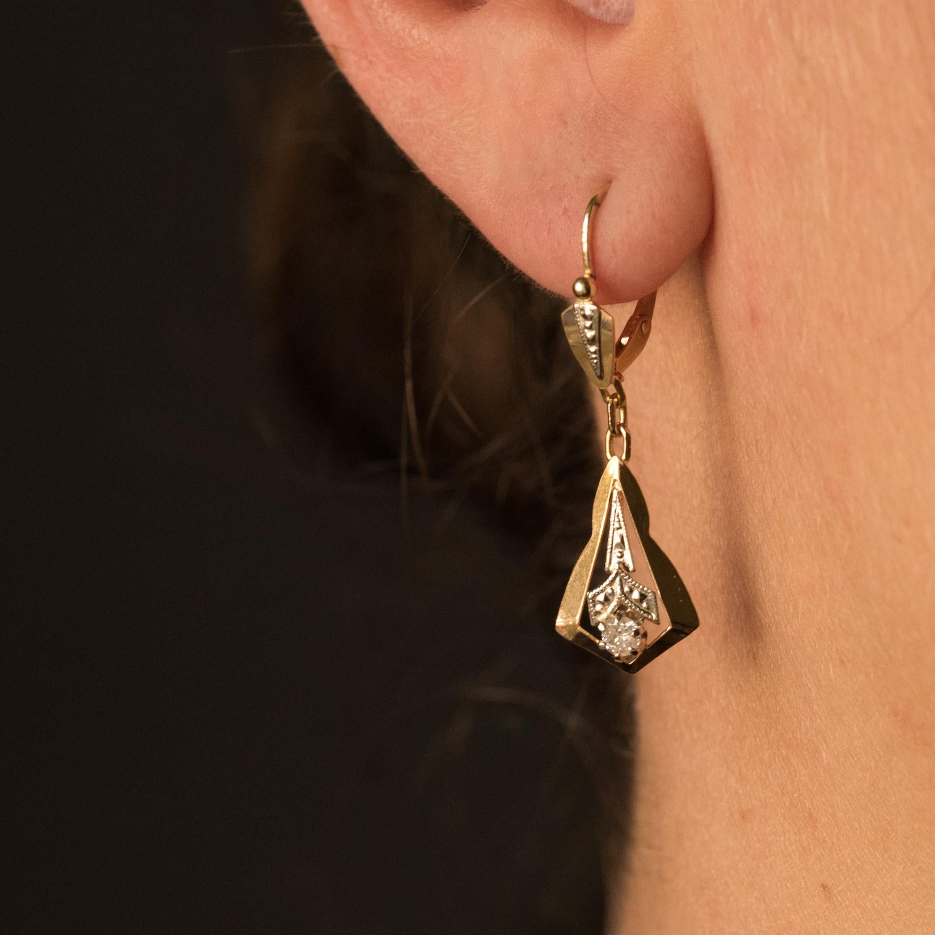 Earrings in 18 karats yellow gold and white gold, eagle's head hallmark.
Delightful dangling earrings, each consists of a sleeper set with a chiseled motif of triangular shape that retains a design 2 gold geometric pattern, pierced, chiseled and set