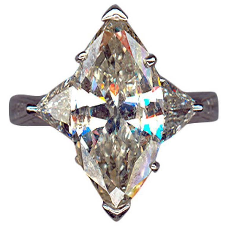 Serti d'un diamant central de taille navette, pureté P2, couleur L, environ 5,02 carats. Sur les deux côtés, 2 diamants triangulaires d'un poids total d'environ 1,20 carats. Serti à l'anneau. En or blanc 18 K. Marqué à l'intérieur avec IK. Poids