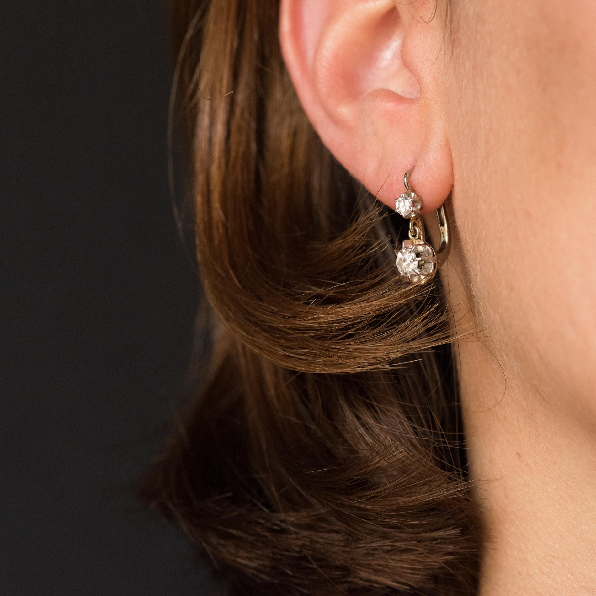 Earrings in 18 karats white gold, eagle's head hallmark.
Each antique lever- back earring is adorned with a brilliant- cut diamond that holds an antique cushion- cut diamond. The clasp is from the front.
Total weight of diamonds: 0.50 carat