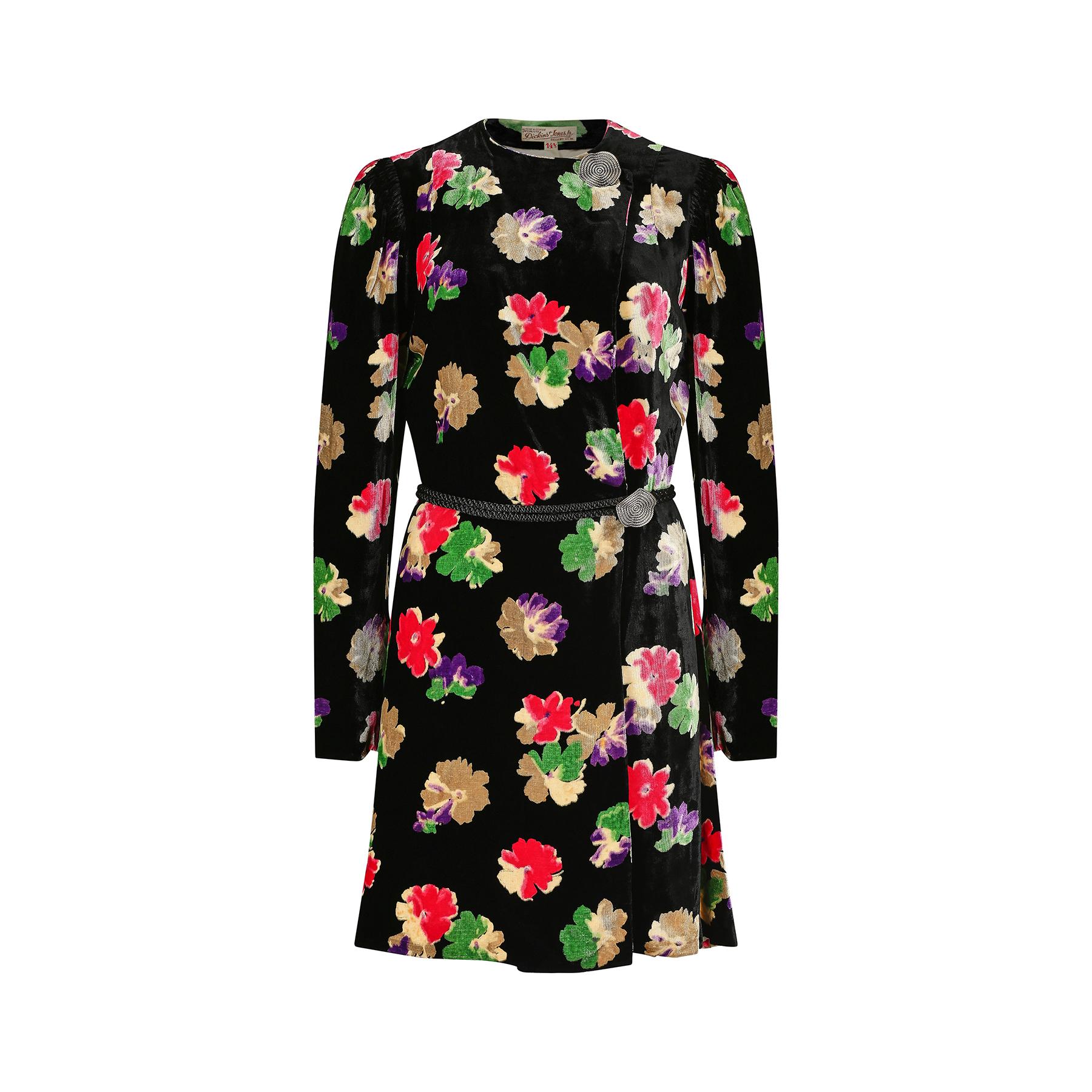 1930s panne silk velvet floral jacket which retailed at the upmarket department store Dickins and Jones in London's Regent Street.  It has a striking repeat floral print in cream, purple, cerise pink and green against a black background. The buttons