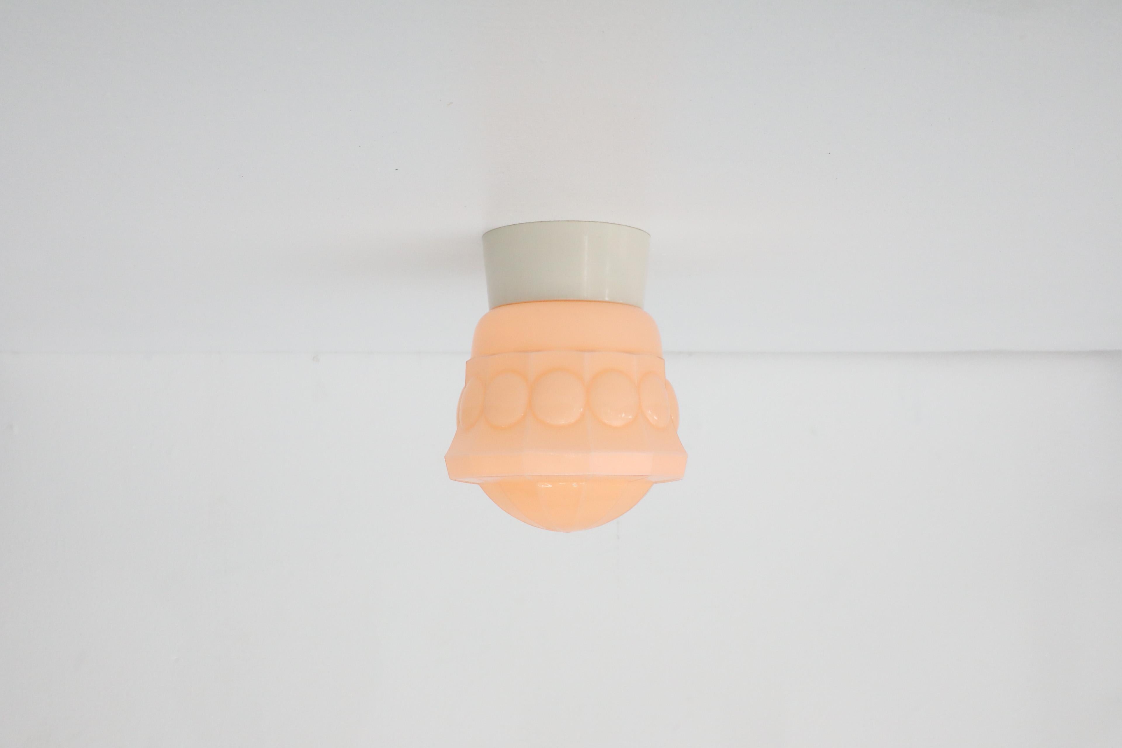 Beautifully stylized, 1930s, Dutch Art Deco mold blown glass ceiling lamp in pale pink manufactured by Thabur. Thabur was a lighting and small appliances company from the Hague, Netherlands. At one point in its 7 decades long history, Thabur was the