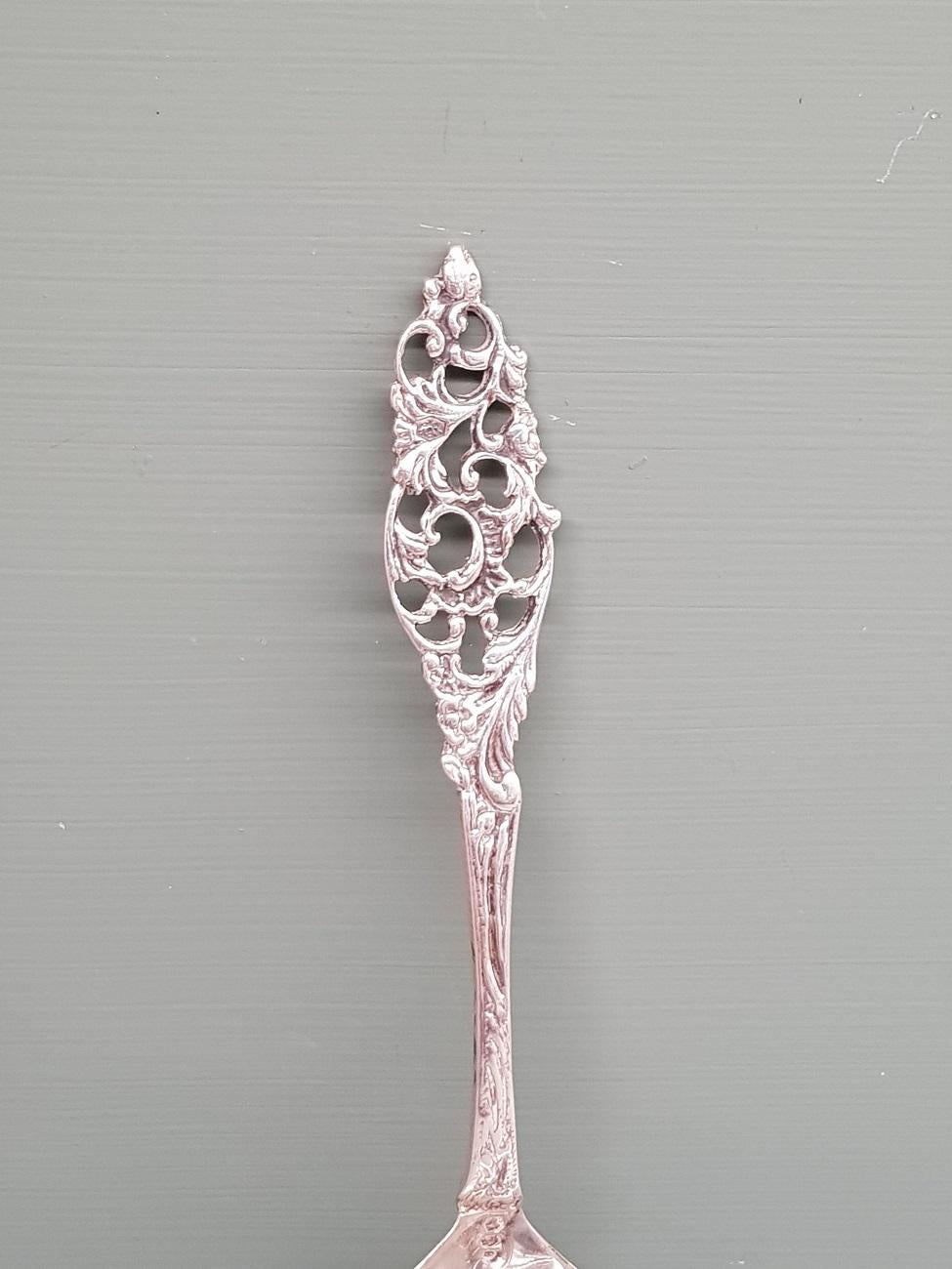 Old Dutch silver sugar spoon decorated with a floral decor and is marked with lion, minerva and year letter C from 1937. It's in a used but good condition.

The measurements are:
Depth 3.5 cm/ 1.3 inch.
Width 4 cm/ 1.5 inch.
Height 16 cm/ 6.2