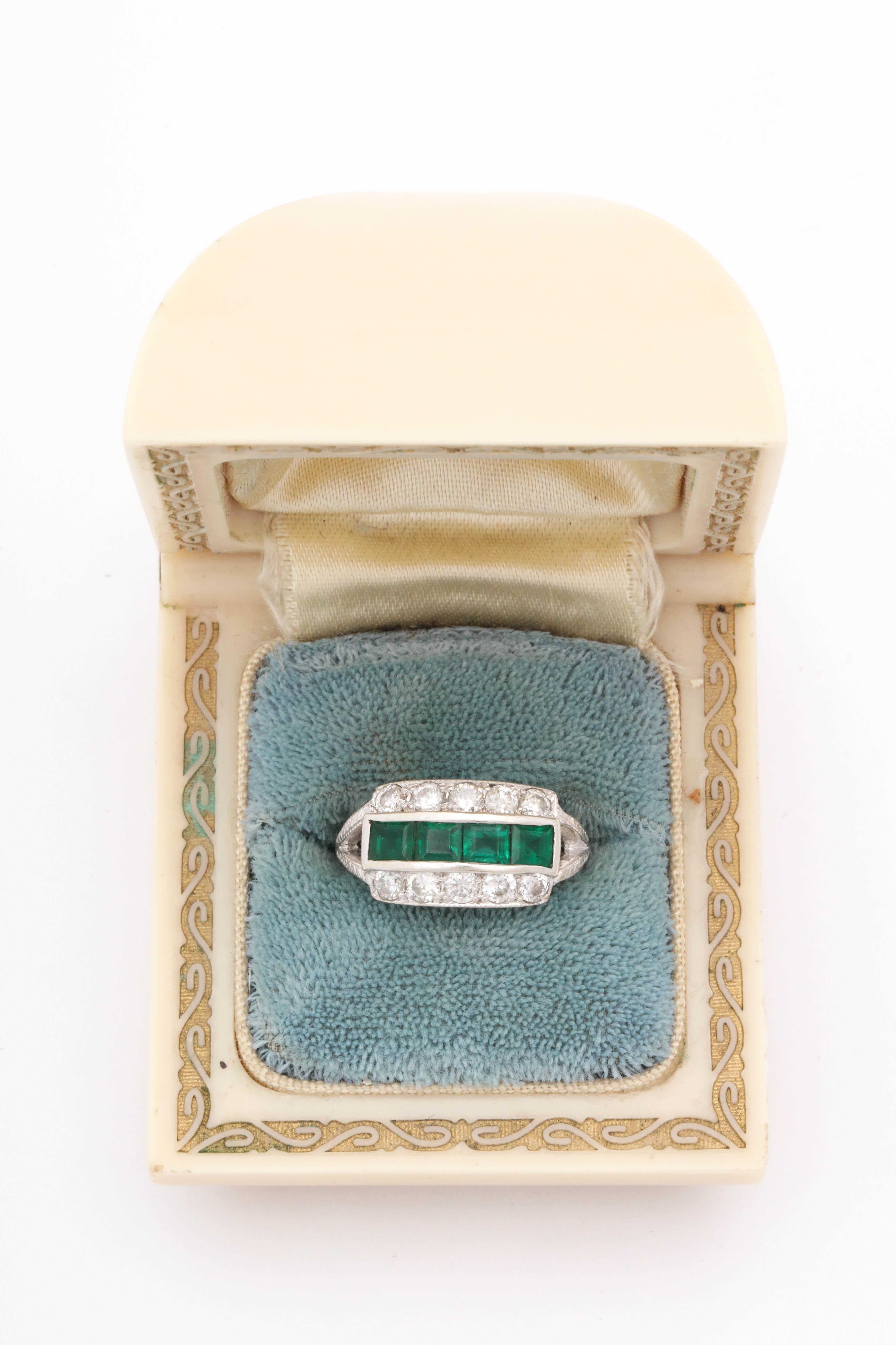 One Ladies Band Style Ring Created In 18kt White Gold Set With [4] Emerald Cut Emeralds Weighing Approximately .75ct Total Weight. Further Bordered By [10] Antique Cut Diamonds Weighing Approximately 1 Carat Total Weight. Ring Size 6 And May Easily