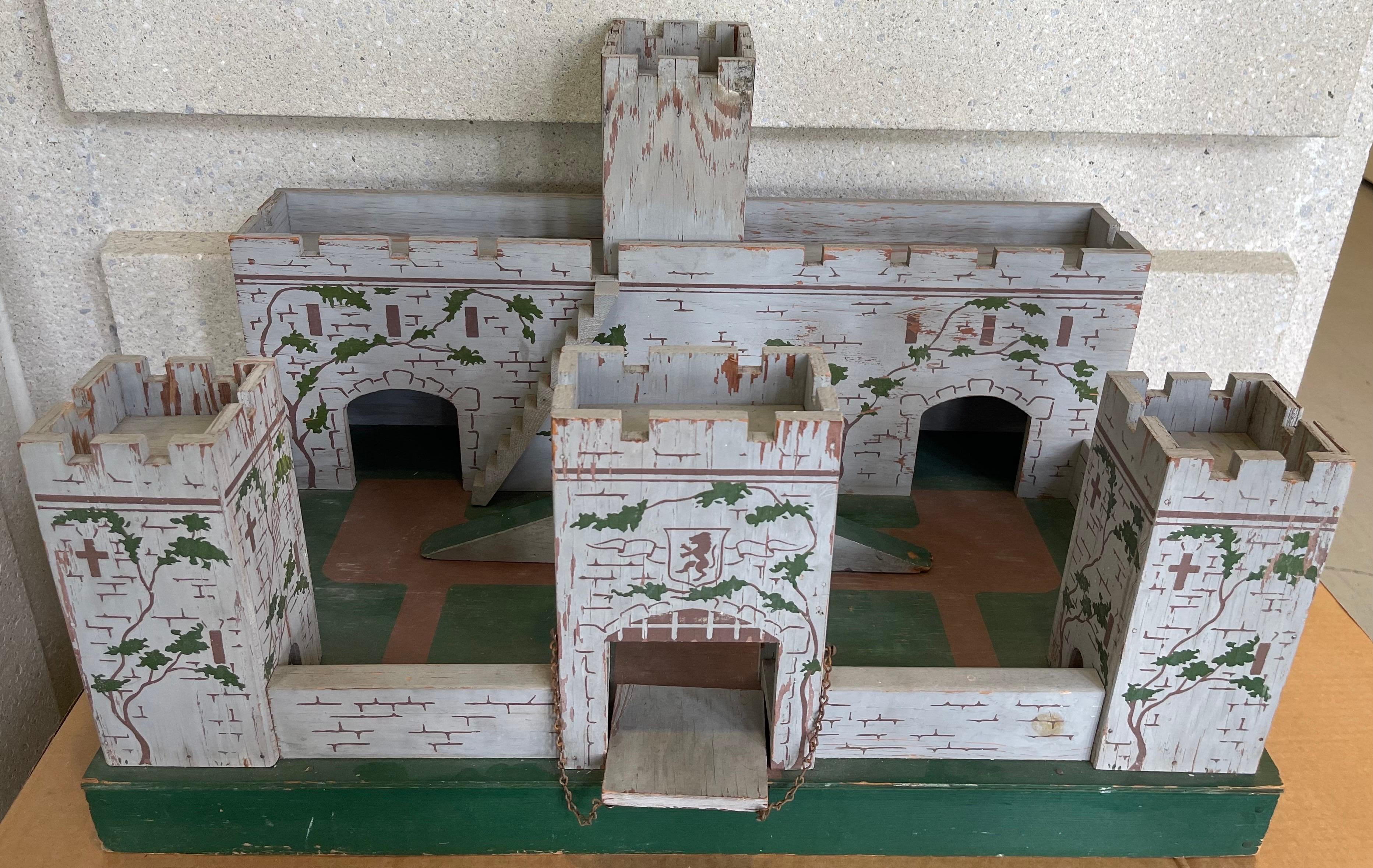 1930s English hand painted wooden toy fort. Made as a toy fort for lead soldiers, the fort included a working draw bridge and moveable ramp. The towers are also removable to assist with transit. 
No makers mark or signature.  
It is possible to ship