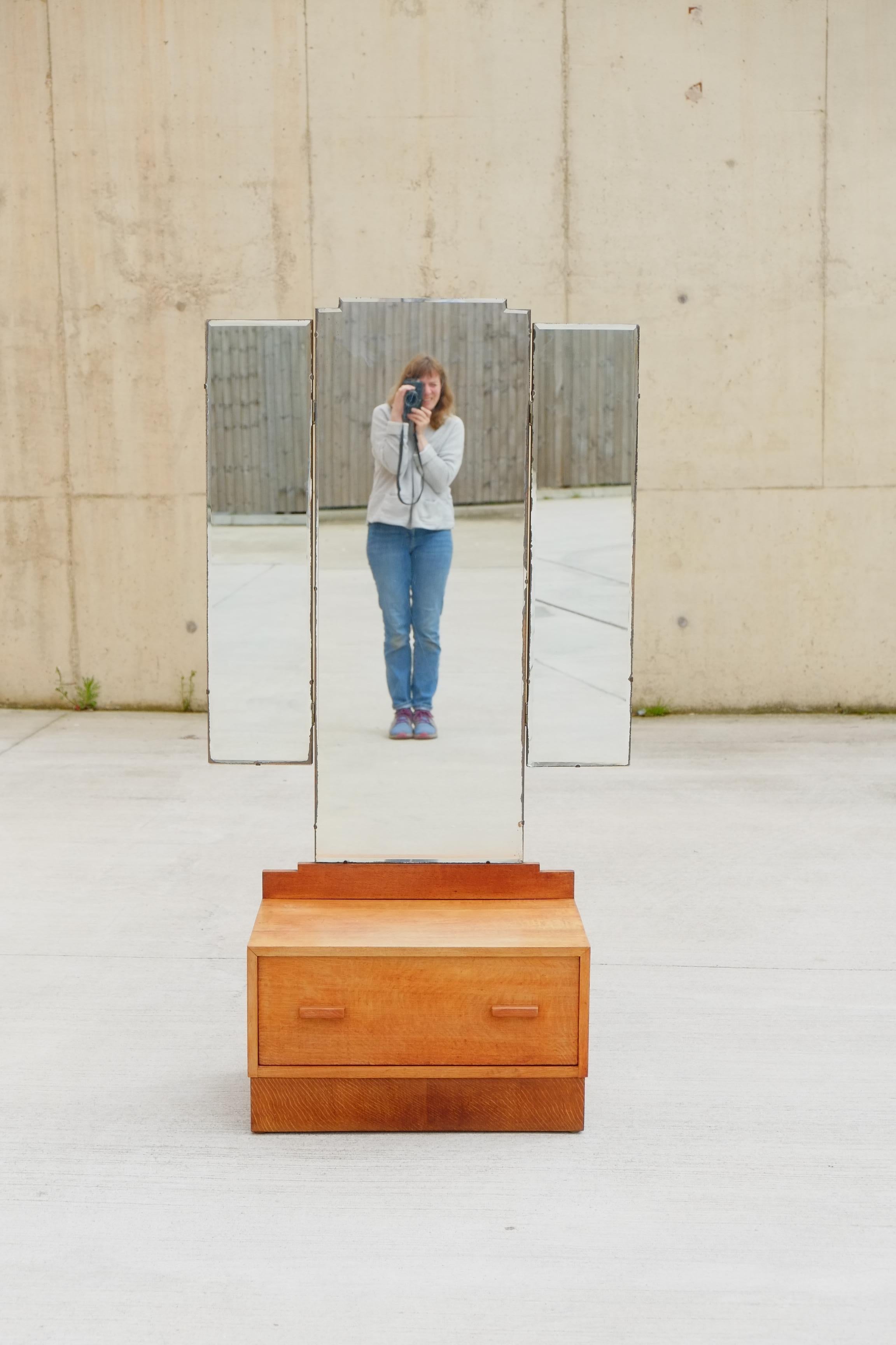 A beautifully simple 1930s Art Deco triple dressing mirror / vanity from England. This vanity has a single deep drawer of solid oak with simple oak wood drawer handles. Above is a large geometric triple folding dressing mirror. 

Size approx; 68.5cm