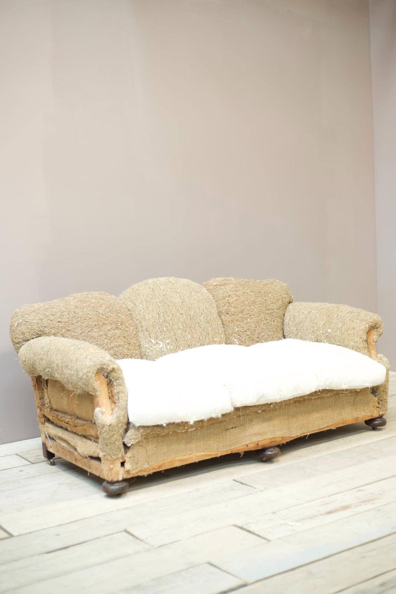 This is a superb quality 1930's country house sofa. Beautiful scalloped back with deep seat and wonderful design arm. What is also rather nice is the shape in the front rail. Very elegant and of course extremely comfy. Bun feet with discreet brass