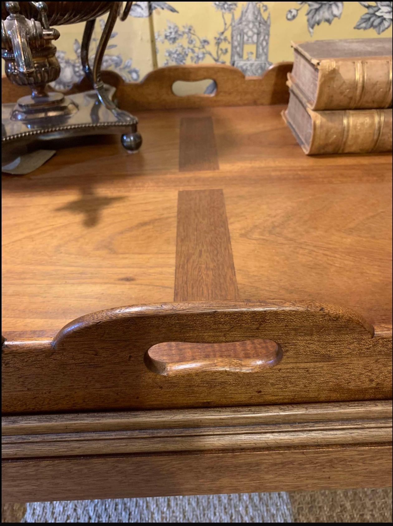 Une belle table à plateau en acajou anglais, reliée par du laiton, datant des années 1930, qui conviendrait aussi bien comme table basse que comme table d'appoint. 
Solide et résistant, le plateau se soulève facilement de la base, ce qui en fait un