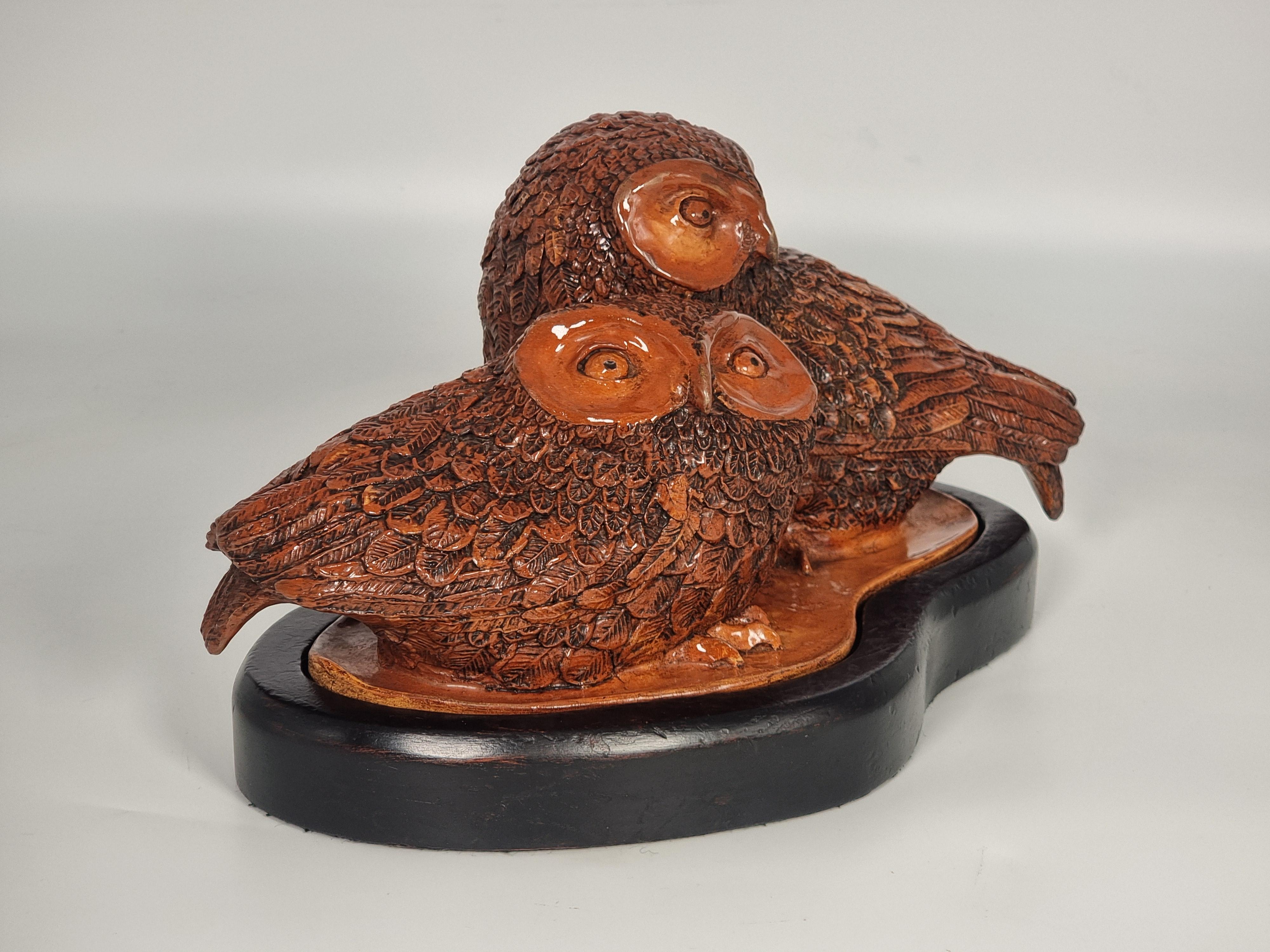 Questa superba scultura in ceramica di grandi dimensioni è modellata a mano in argilla cotta in forno con un ricco smalto rossastro e dettagli sfumati.

Raffigura una coppia di giovani gufi seduti insieme in attesa che il genitore torni a nutrirli.