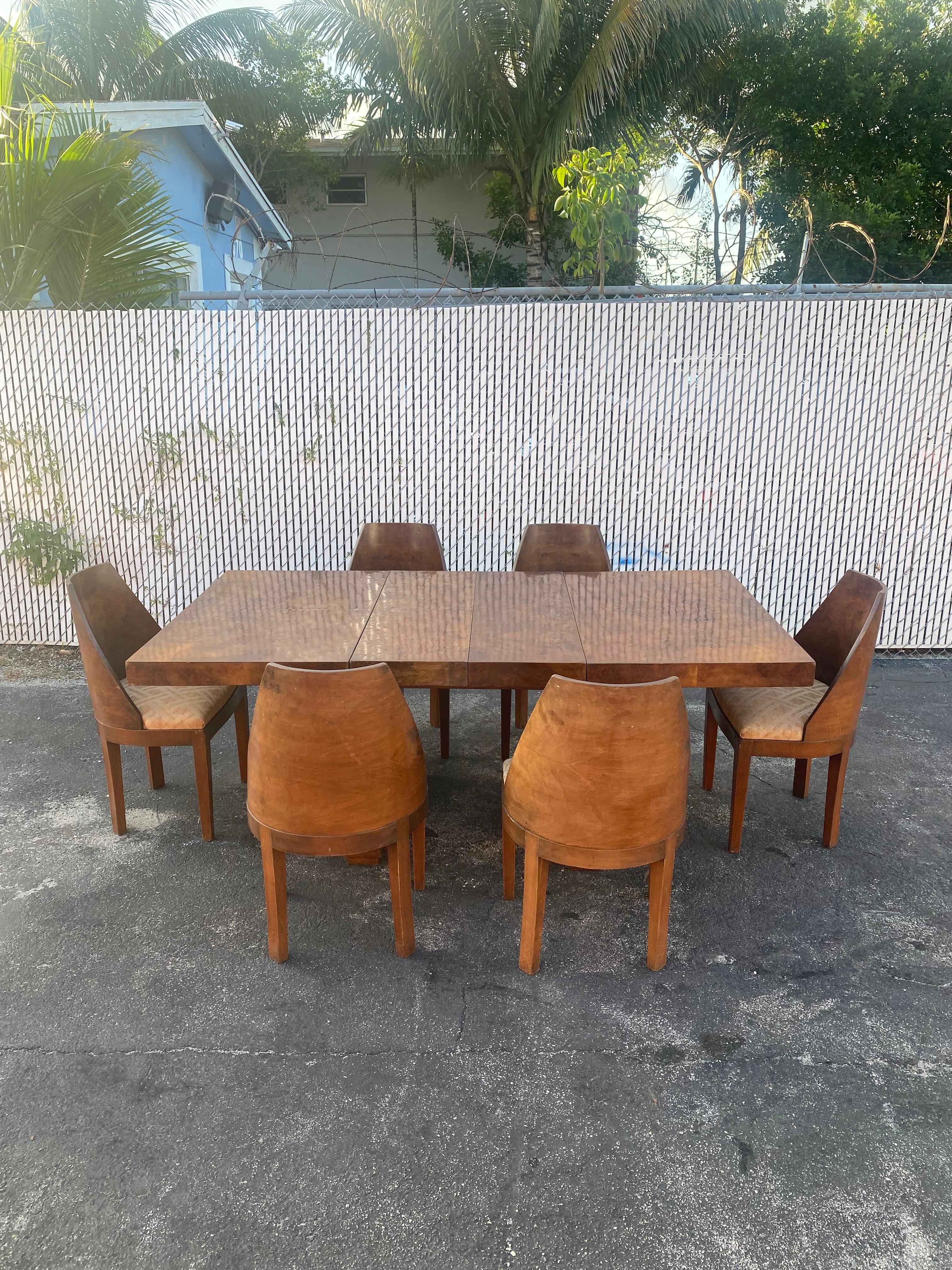 On offer on this occasion is one of the most stunning, rare, complete Art Deco dining set you could hope to find. Outstanding design is exhibited throughout. The beautiful walnut dining table and chairs In the style of Gilbert Rohde are statement