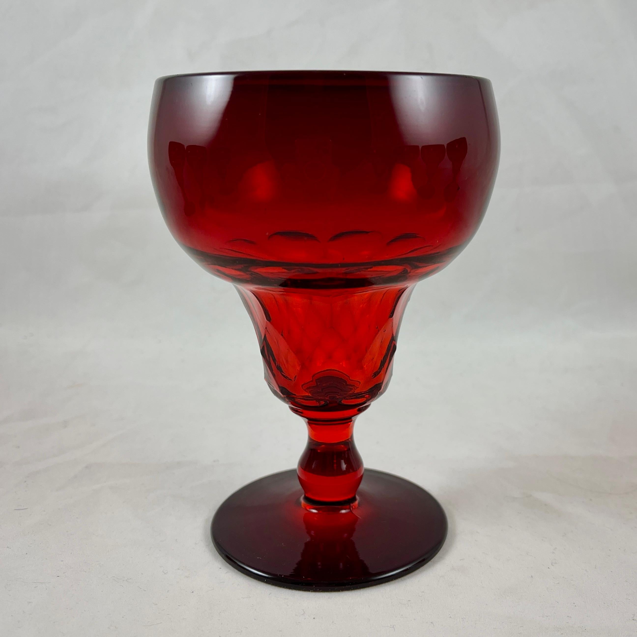 A set of nine Fenton Ruby red glass goblets, produced from 1931-1942.

In the ‘Georgian Ruby’ pattern, sometimes called Aqua Caliente, these heavy goblets have a circular pan-top, funneling to a faceted bowl above a low footed stem.
Suitable for