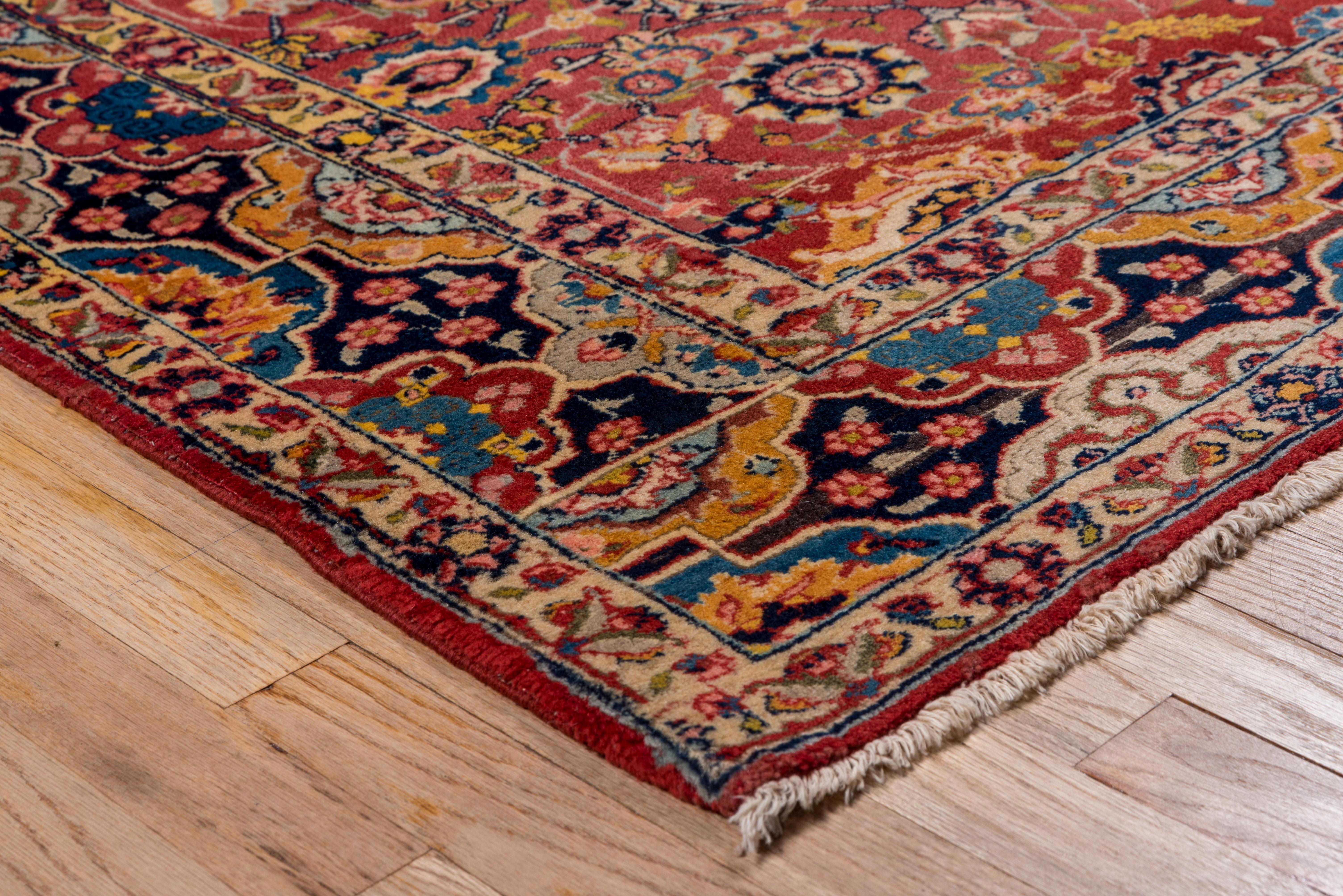 In the classical manner, this top condition, thick pile well-woven NW Persian city scatter features a red field with racemes, rinceaux, various palmettes and rosettes and layered laurel branches, all within a navy border with half cartouches in