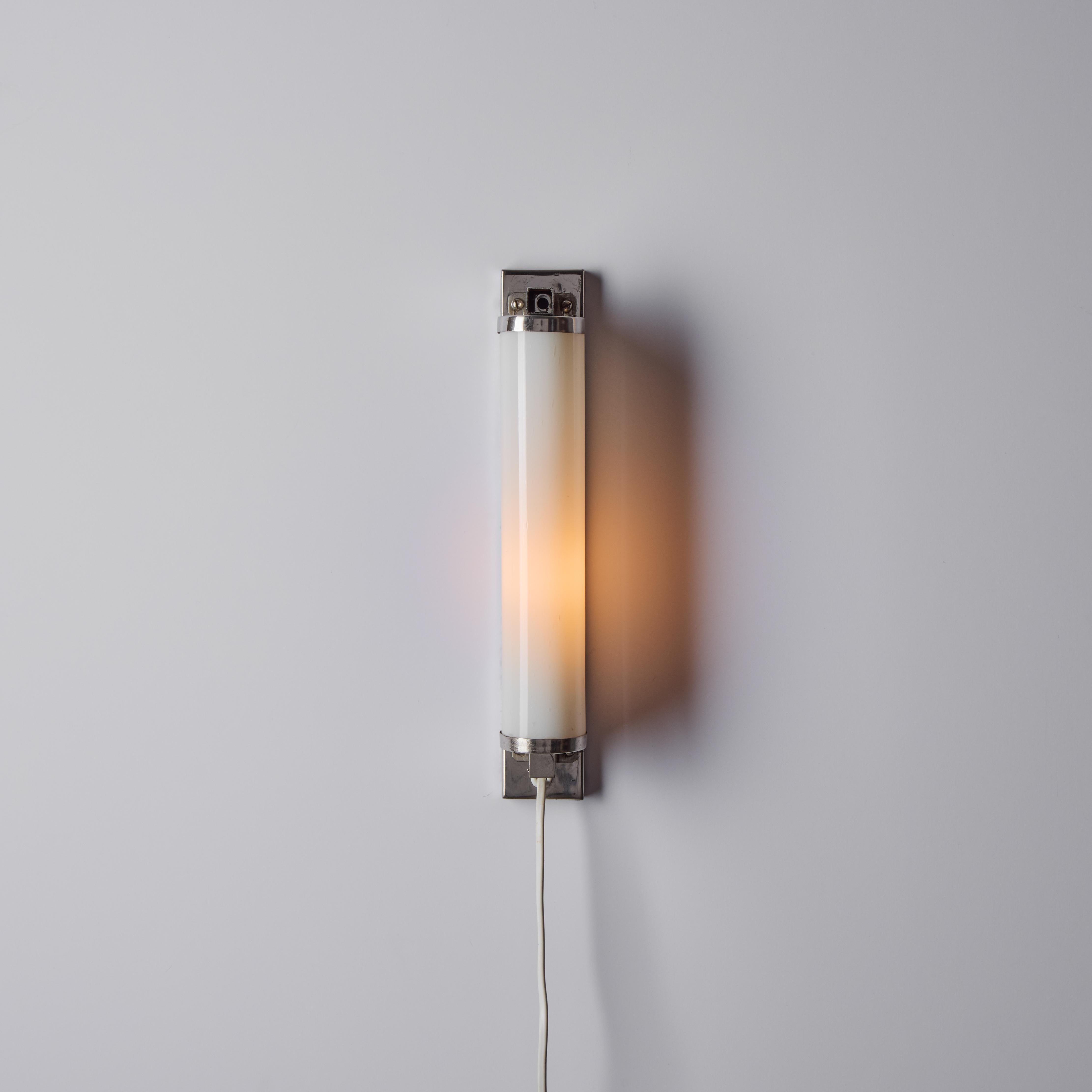 1930s Finnish Cylindrical Glass Plug-in Wall Lamp in the Manner of Paavo Tynell. A highly refined wall lamp executed in opaline glass with attractively patinated chrome frame. A highly functional design of deceptive simplicity, these wall lights