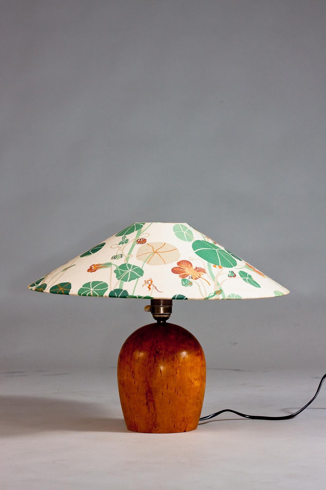 Aggiungi un tocco di eleganza vintage alla tua casa con questa lampada da tavolo in legno finlandese degli anni Trenta. Realizzata con un solido piede in betulla riccia, questa lampada emana un fascino scandinavo senza tempo. Il paralume a tema