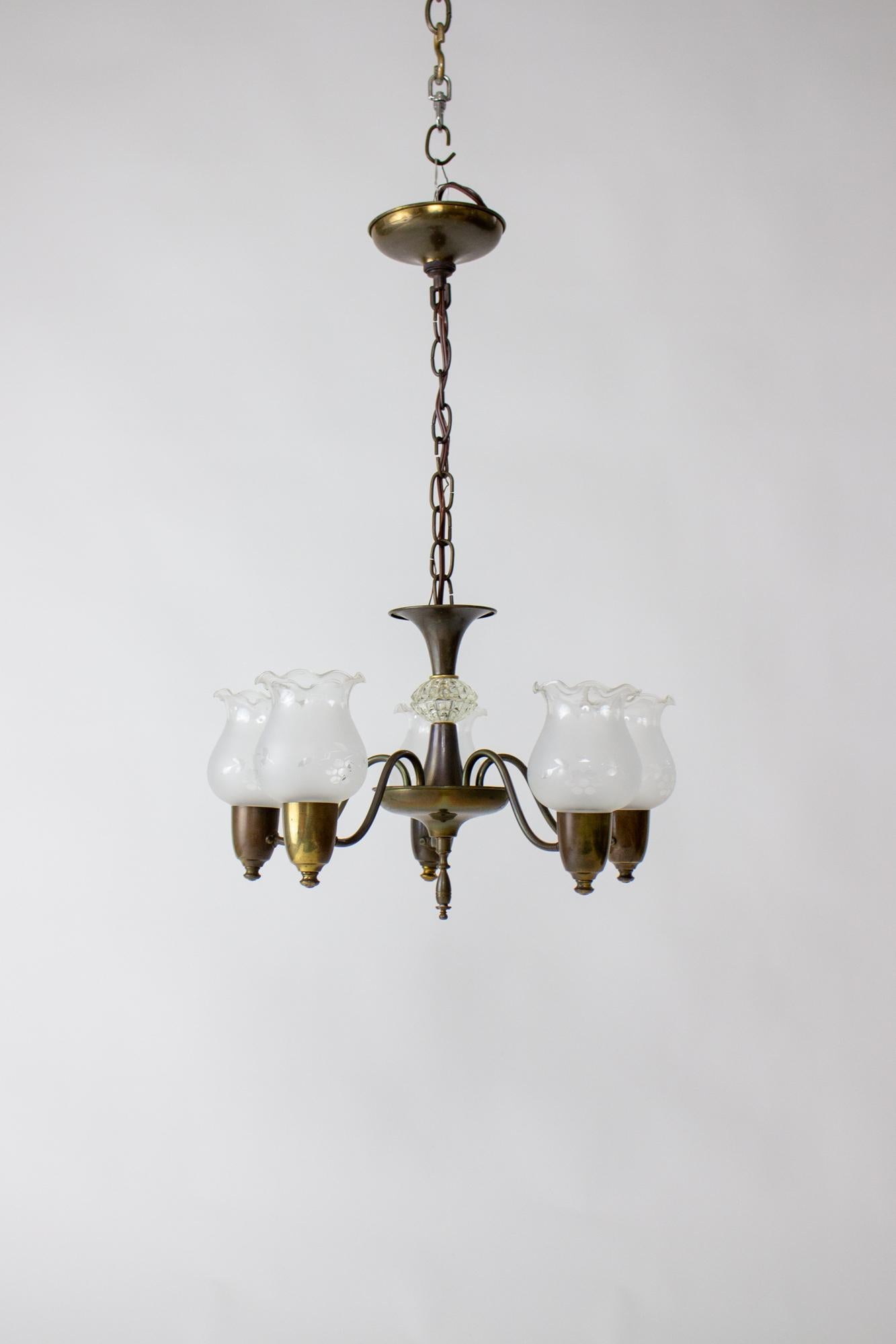 1930’s Five Light Art Deco Chandelier. Brass with an aged patina. Glass piece in stem. Frilly frosted glass shades with etched grape pattern. American, C. 1930

Condition: Aged brass patina, cleaned and wax polished. Rewired and ready for