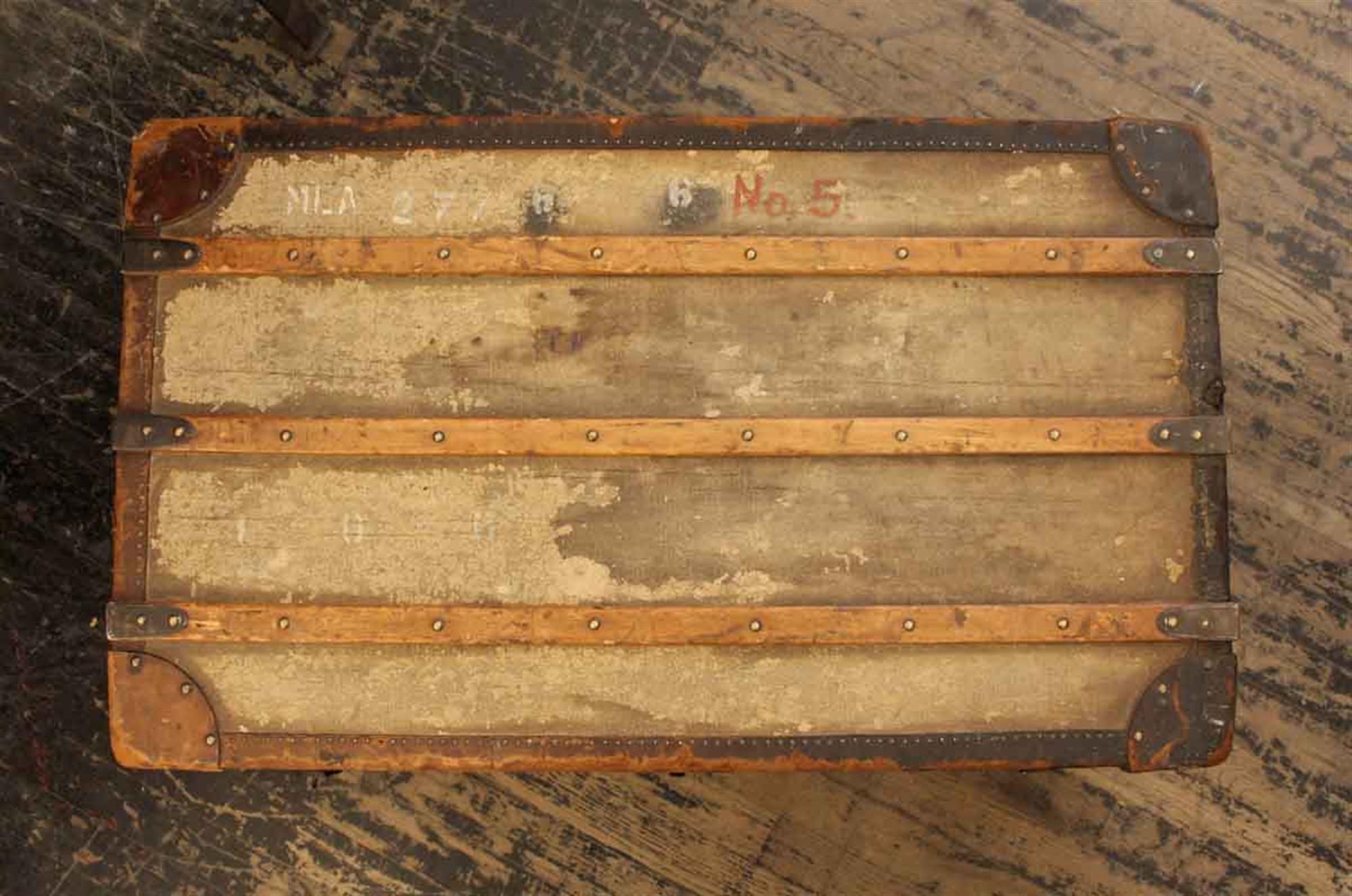 1930s flat top distressed wooden shipping trunk with leather detail on the corners. This is very nice for display or to use as a low coffee table. The handle on one side is broken. This can be seen at our 302 Bowery location in Manhattan.