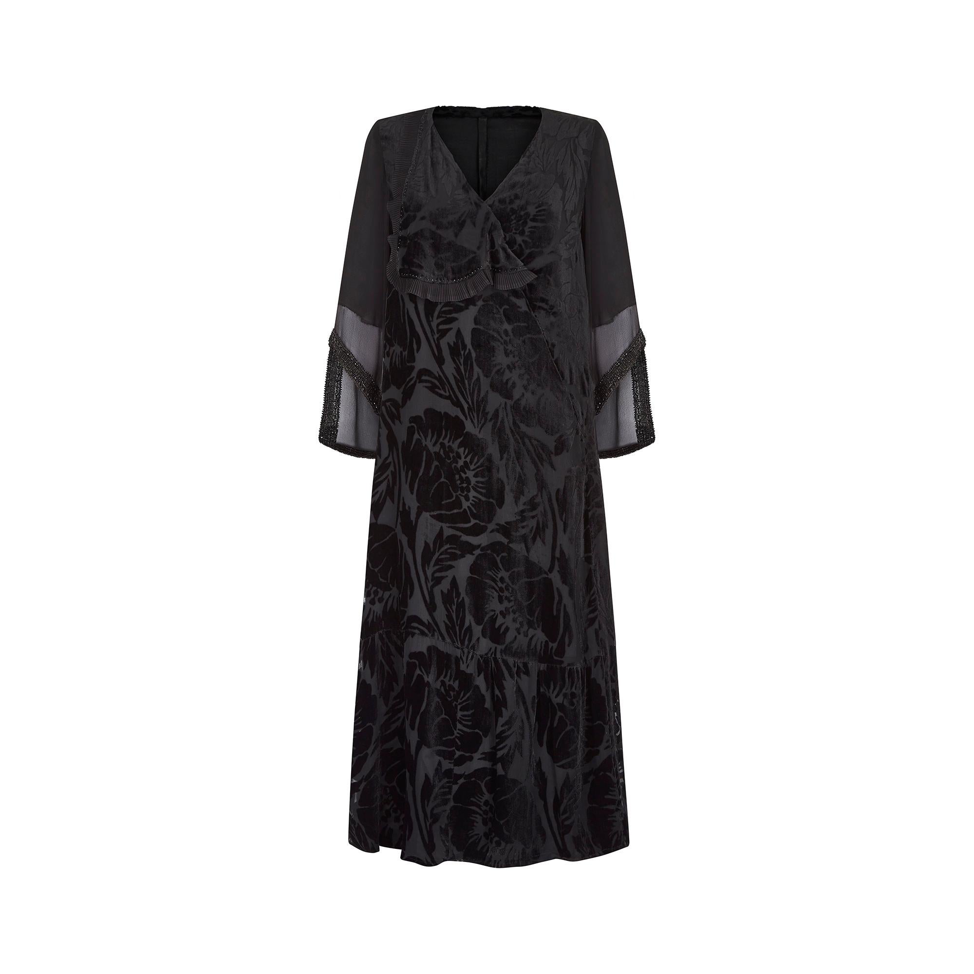 Black velvet and silk 1930s dress with a V-neck crossover front and frilled mesh trim finished with delicate beading. The dress has silk georgette fluted sleeves which are semi transparent and finished with further intricate black beaded detail to