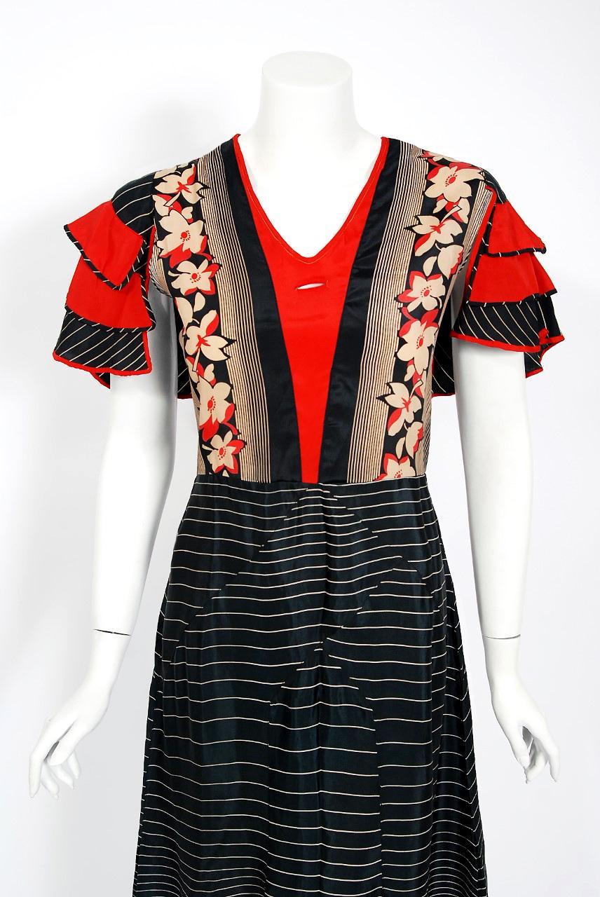 The dynamic floral deco stripe print used for this 1930's silk day dress has a fresh innocence that I find irresistible. The bodice has the most unique tiered ruffle split-sleeves and front slit for an optional scarf detail. The dress tapers into a