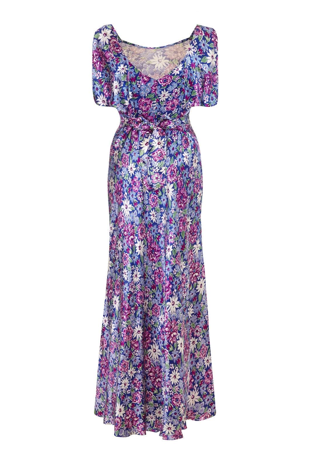 This incredible bias-cut satin full length dress was created in the 1930s and retailed by Kendal Milne & Co Ltd, the best department store in Manchester and a division of Harrods from 1919 until 1959. Hand-crafted from smooth cobalt blue satin with