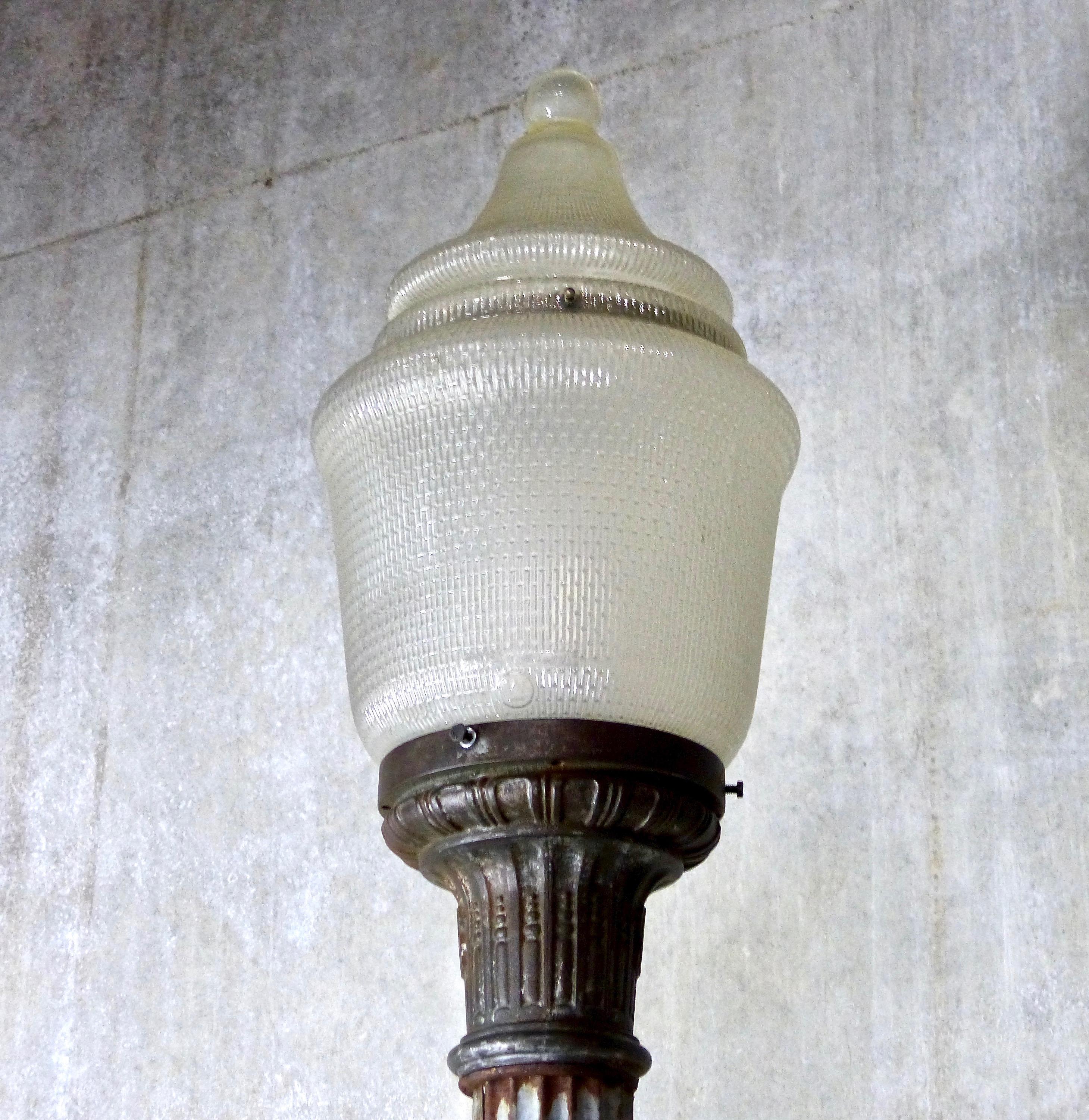 An extraordinary, 10-foot high American made street lamp from the 1930s. Zinc fluted column with cast metal base and top lamp fitter. Includes the original glass acorn shade. Rare and spectacular!
fully functional.