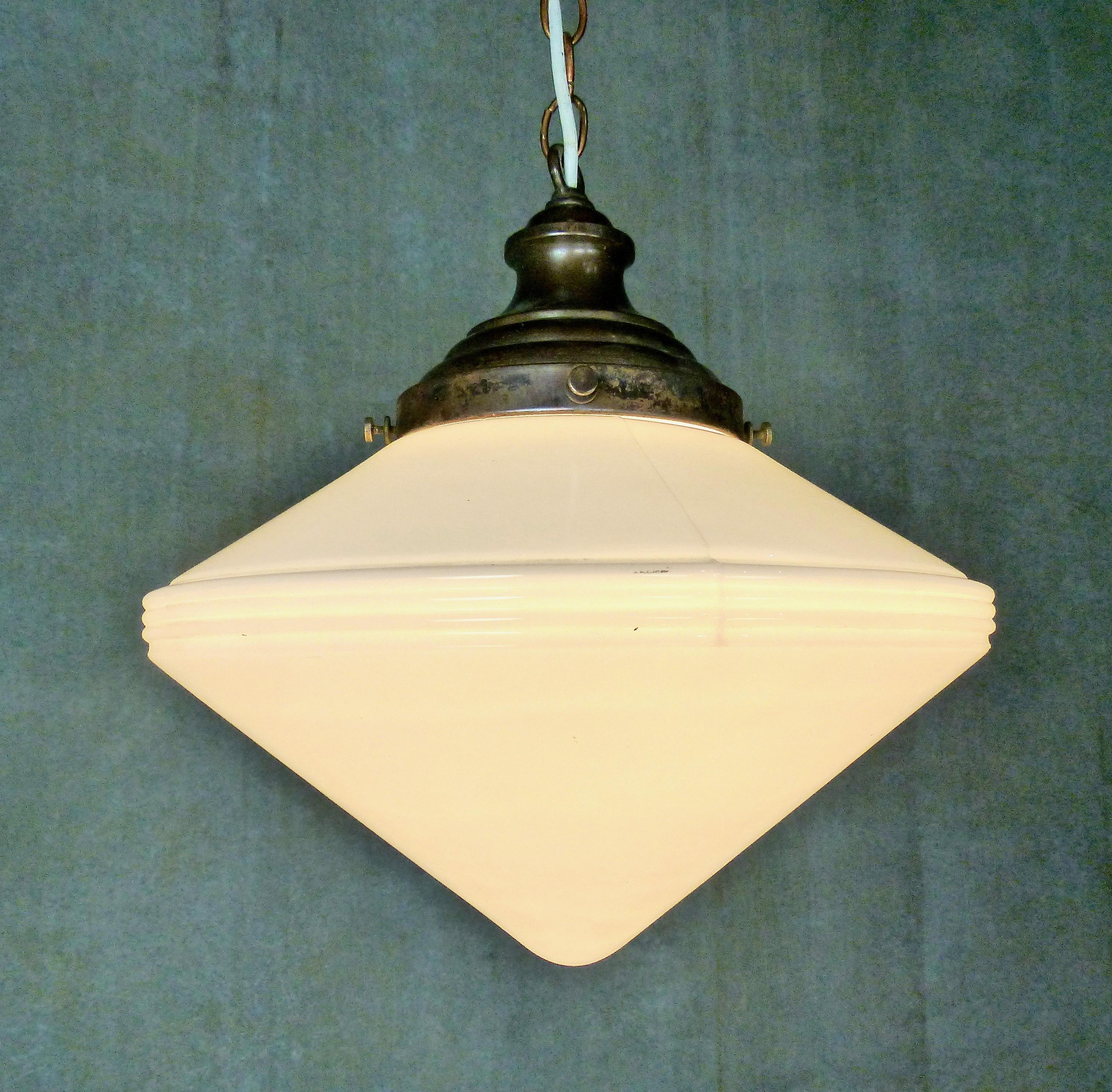 Double pyramid-shaped milk glass shade with a ribbed center band. Original copper fitter on an intriguing pendant light. Re-wired and CSA approved to current electrical standards; ceiling mounting plate included. Currently hangs at 36” but could be