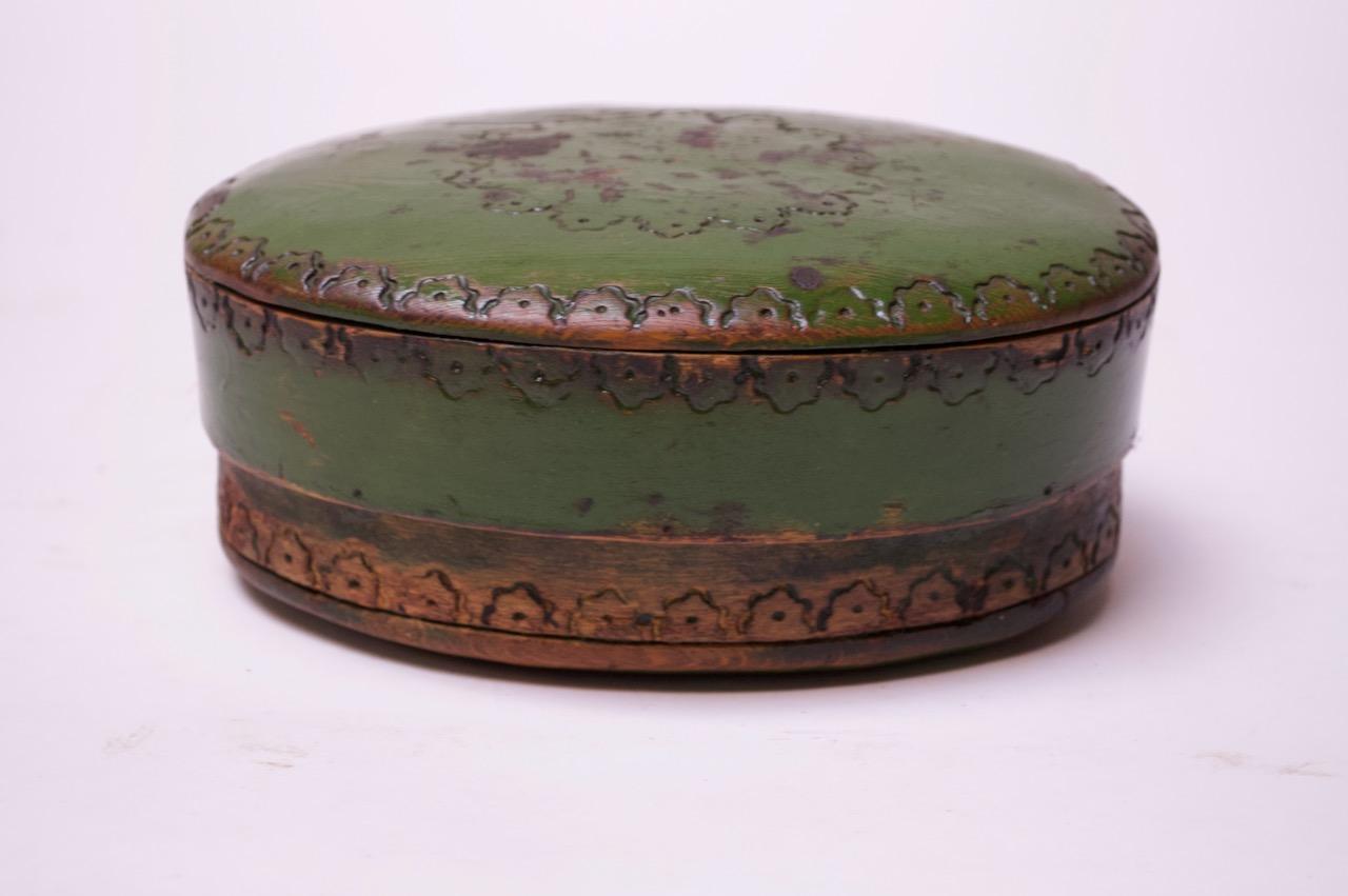 1933 Victorian style Folk Art soap box / keepsake box composed of an oval wooden lid and box in original green paint. Intricate wood-burning detail present (reminiscent of leather hand-tooling). Paint loss / soiling (particularly to the lid and