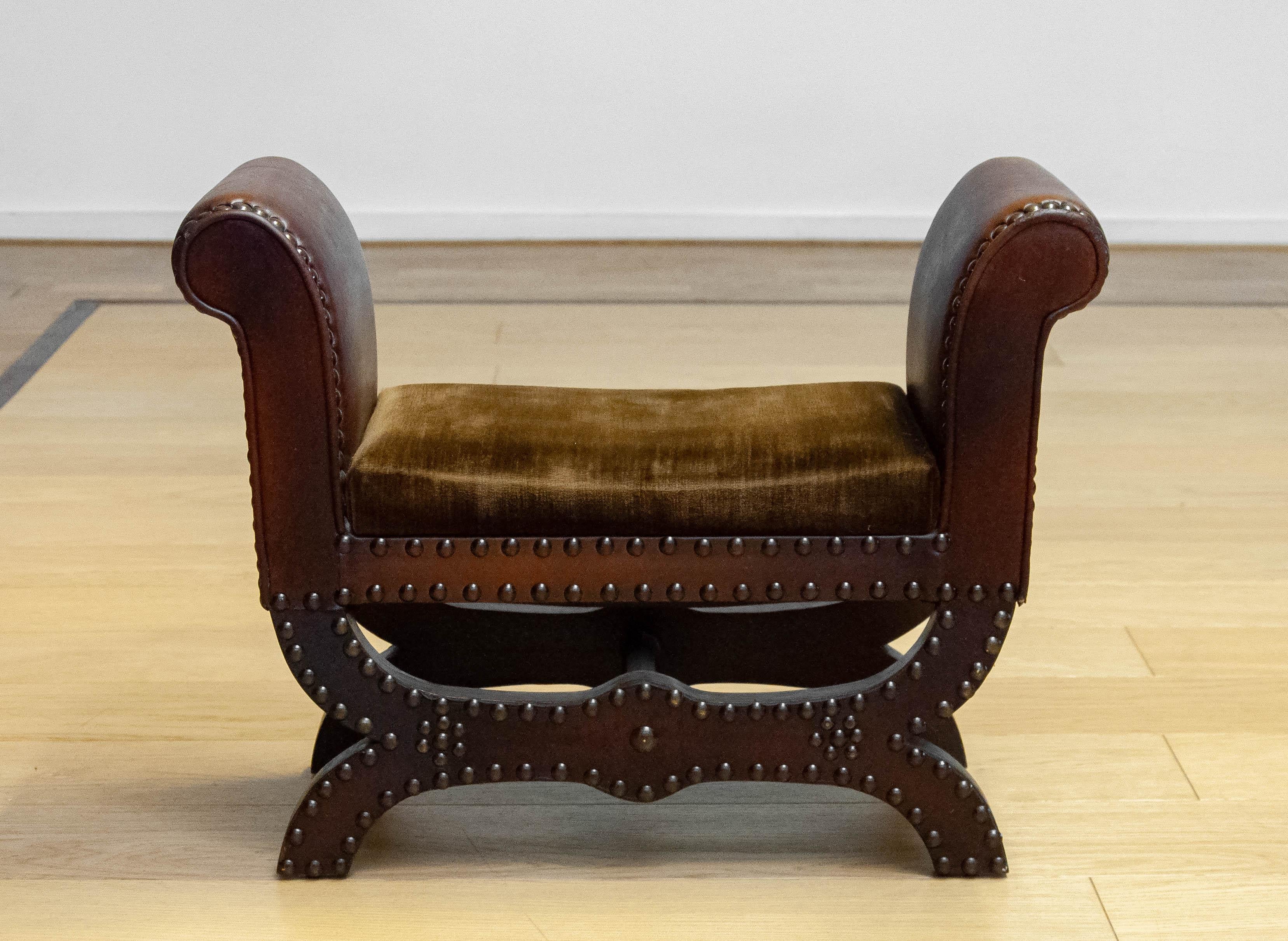 Tabouret de caractère fabriqué par Boet en Suède dans les années 1940. Ce banc rare et raffiné possède une base en bois de forme élégante, richement finie avec des clous décoratifs en métal, ce qui donne à l'ensemble une apparence robuste mais