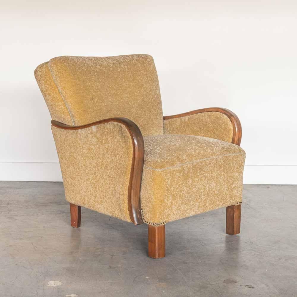 Stunning upholstered armchair from France, 1930's. Vintage upholstery in a muted chartreuse chenille with some light spots of age and wear. Beautifully curved wood arms and carved wood feet in dark stain. 