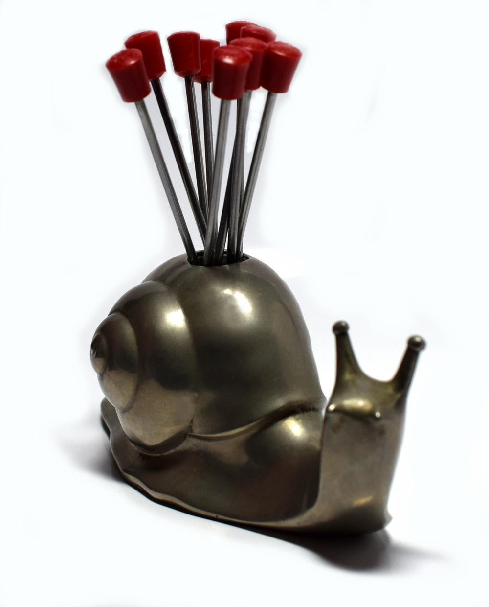 1930s French Art Deco novelty cocktail stick holder in the form of a large snail with nine red bakelite and chrome cocktail sticks. The condition throughout is excellent.