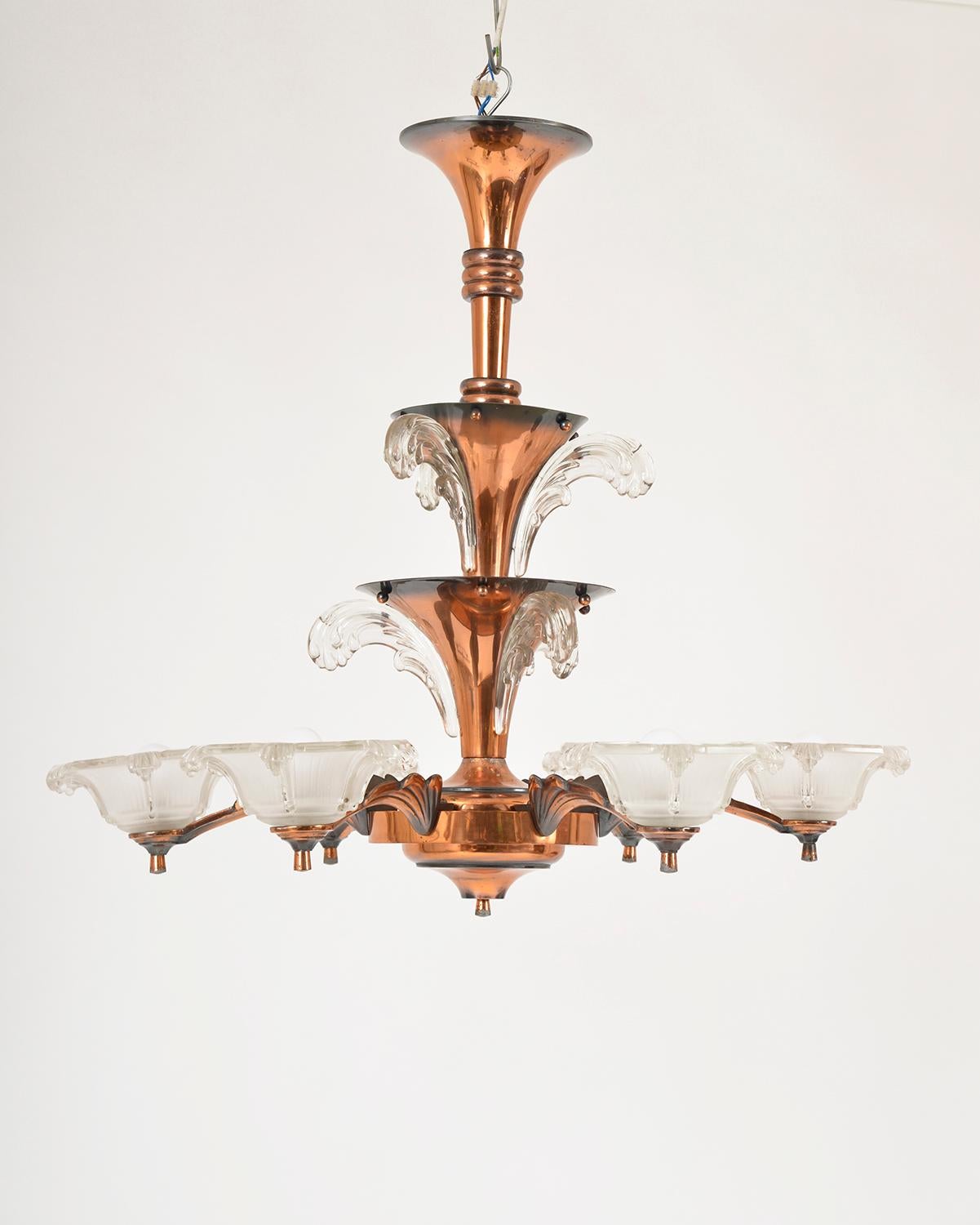 This beautifully organic 1930s French Art Deco chandelier was designed by Atelier Petitot. The frame of the chandelier has three trumpet cascading tiers, which have an aged copper effect, off which extend six arms with frosted flower glass shades.