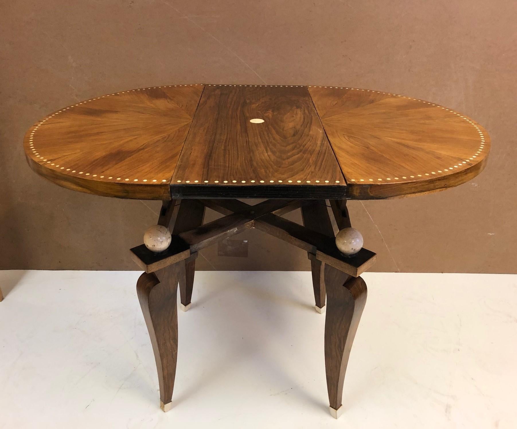 1930s French Art Deco adjustable table. The table is walnut with bone inlay to the top and the sabots are bone as well. Has four round painted accents underneath the tabletop. This table can be adjusted from a side table to a breakfast