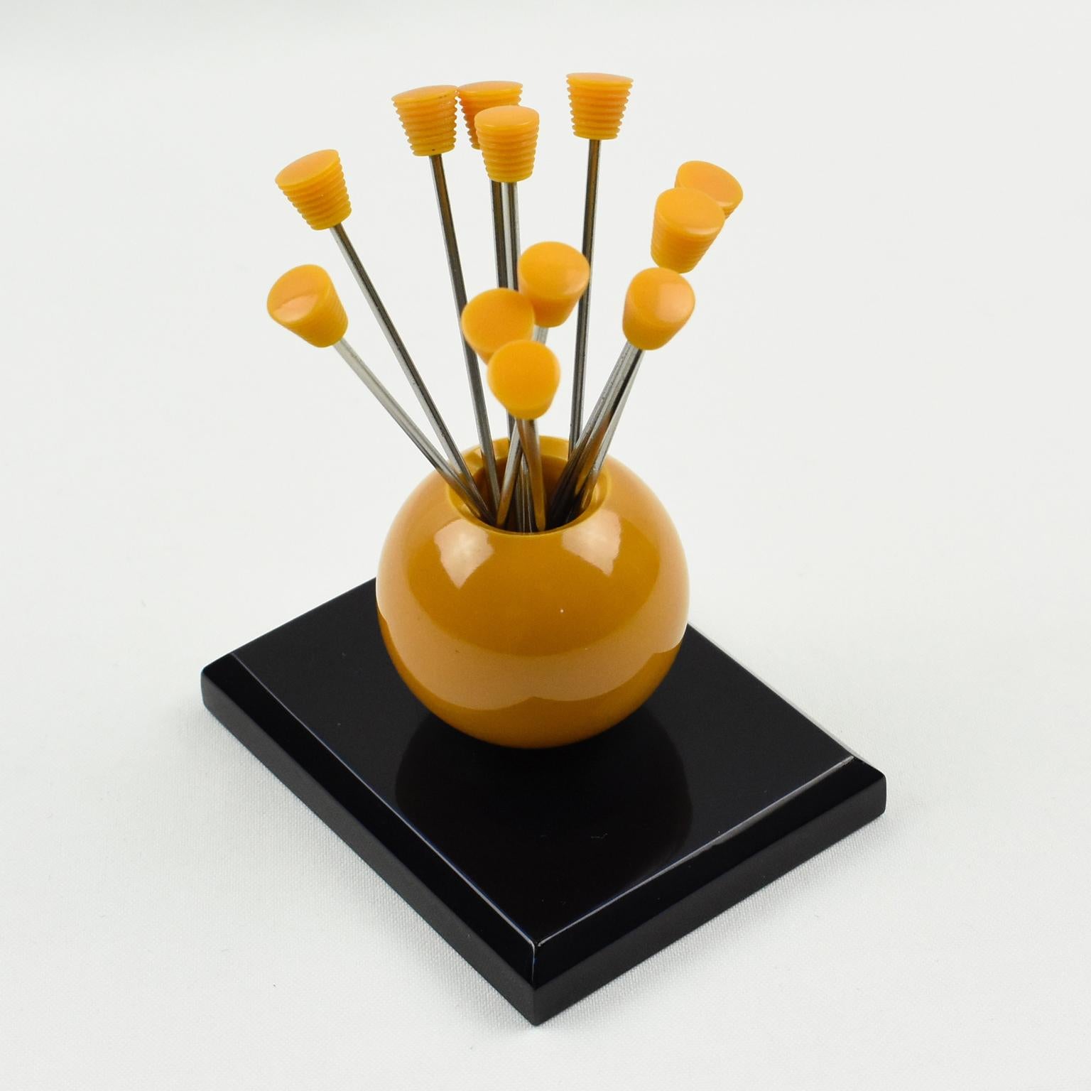 Lovely set of cocktail picks with geometric design. Twelve forks with orange carved Bakelite finial can be removed from the central holder and be used as cocktail picks for Manhattan's, Martinis or any other cocktail that requires a garnish. Orange