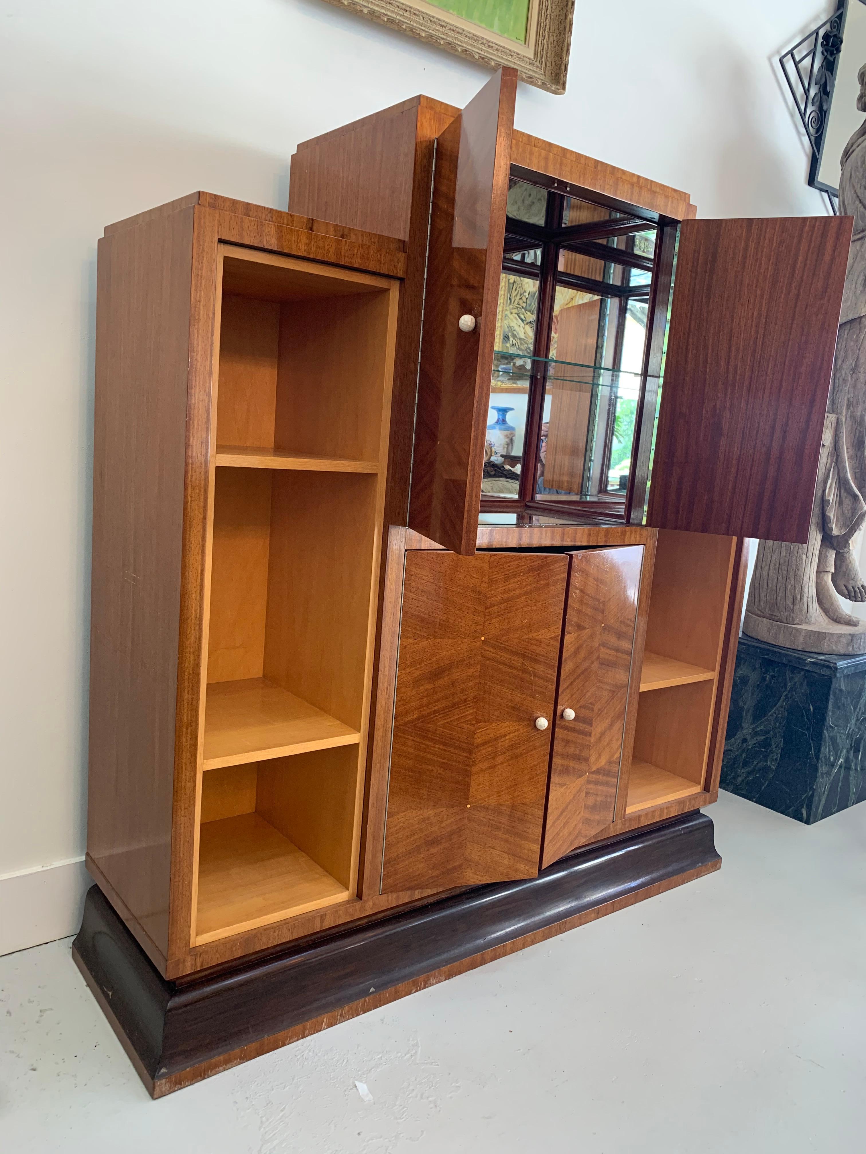 In the manner of Emile Jacques Ruhlman. Bar Cabinet with open sides compartment and two central compartments with doors, upper side with mirrors and glass division. 
Beautiful marquetry and nacre handles.