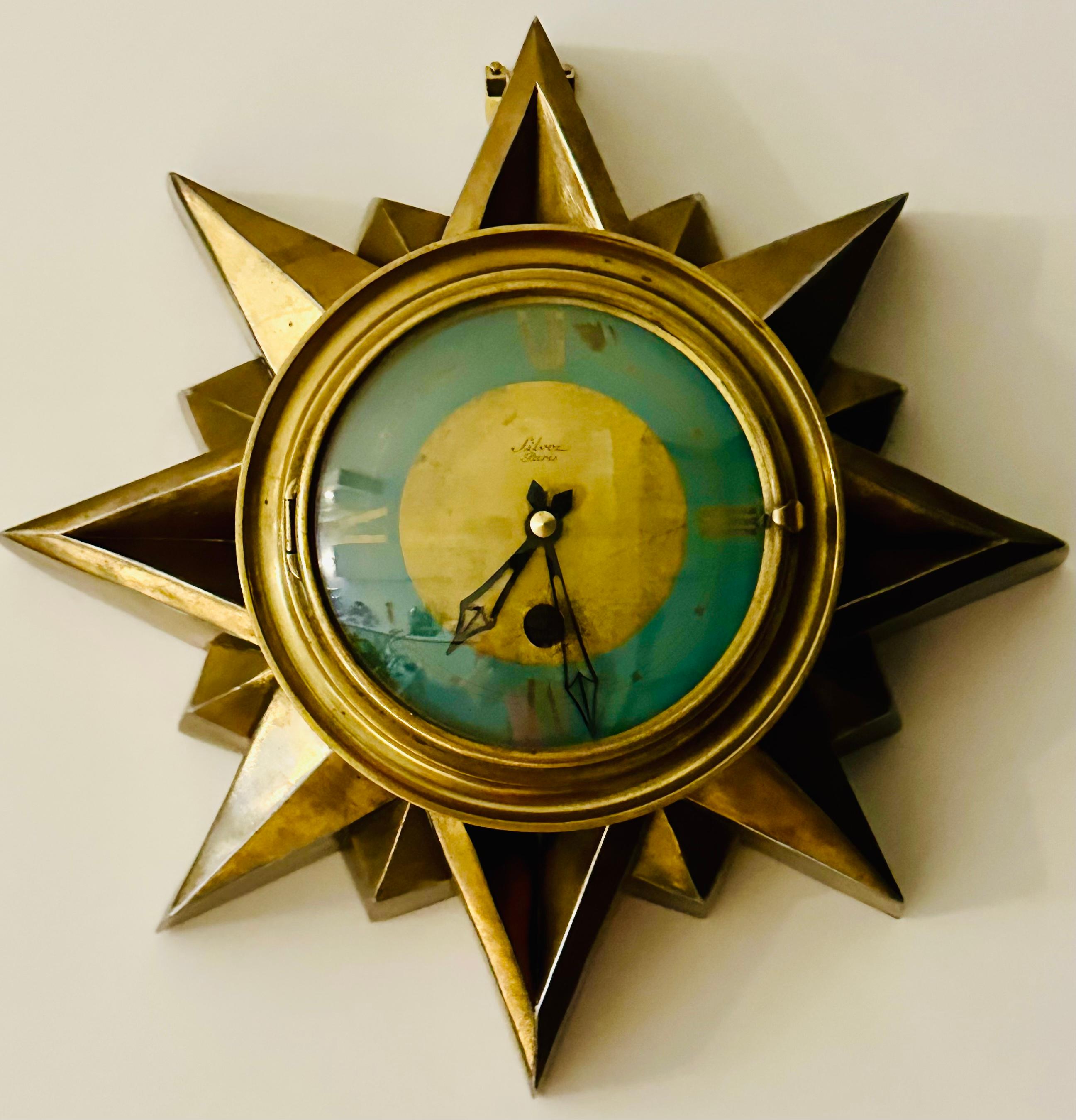 1930s Art Deco French Parisian brass sunburst wall clock manufactured by Cartel Silvoz Paris. The clock is made of brass-plated steel formed into an interesting sunburst design with a series of angled-triangular sun rays of varying sizes which burst