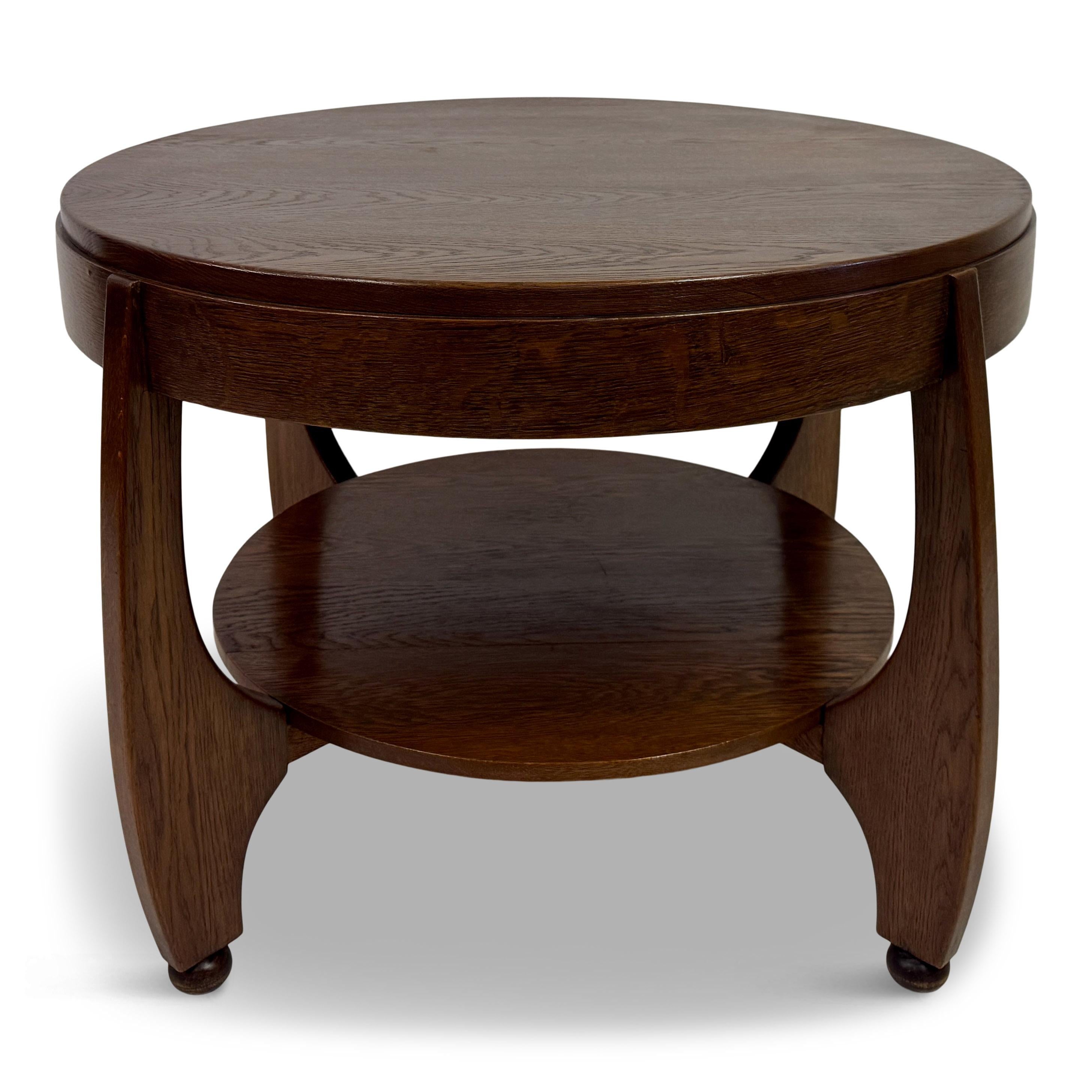 Art Deco Couchtisch oder großer Beistelltisch

Ein wunderschön gearbeiteter Art Deco Couchtisch aus Eichenholz aus den 1930er-1940er Jahren, der die eleganten Kurven und die raffinierte Handwerkskunst der Epoche zeigt. Die runde Tischplatte ruht auf