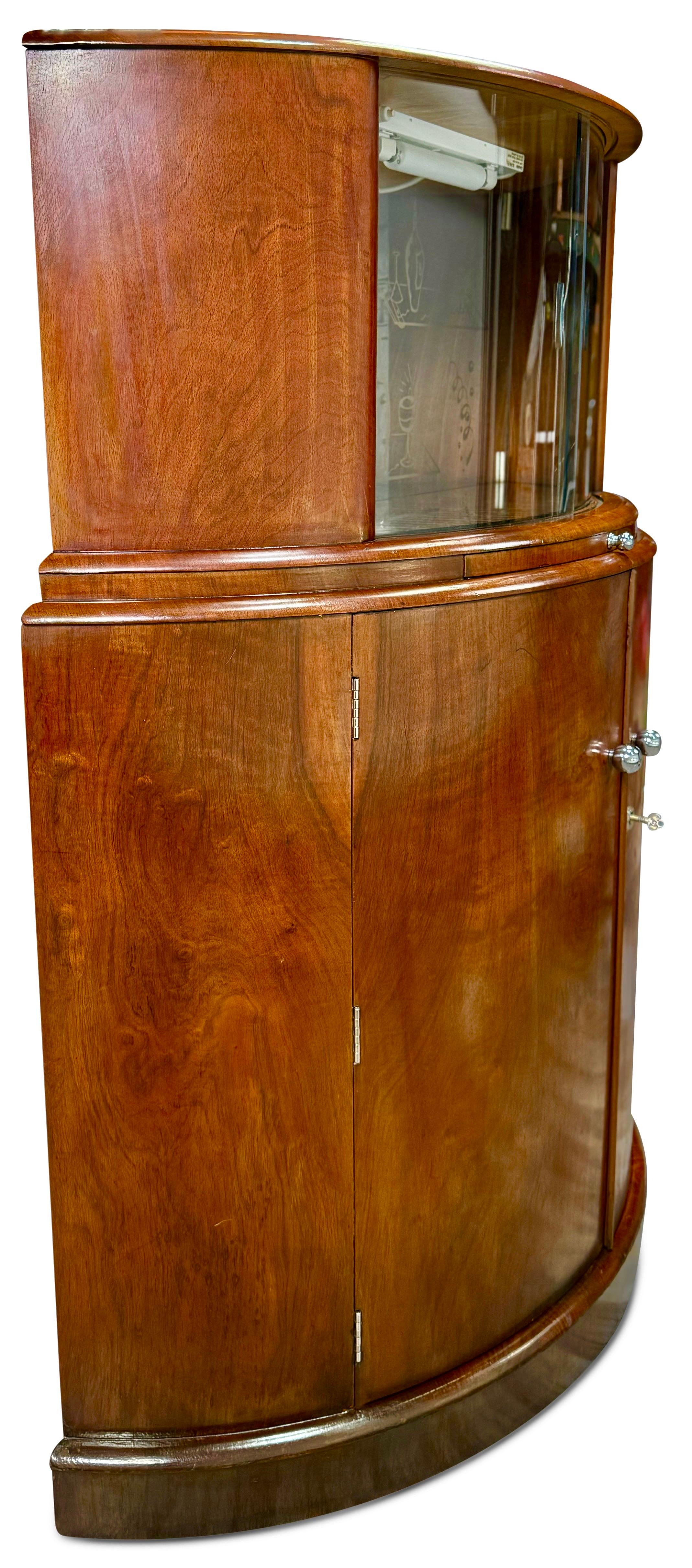 Cet exquis meuble de bar à cocktails en demi-lune, fabriqué en noyer ronceux, date de l'époque Art déco. Il comporte un plateau de bar sec équipé d'une glissière coulissante pour la préparation des cocktails. En ouvrant les deux portes coulissantes