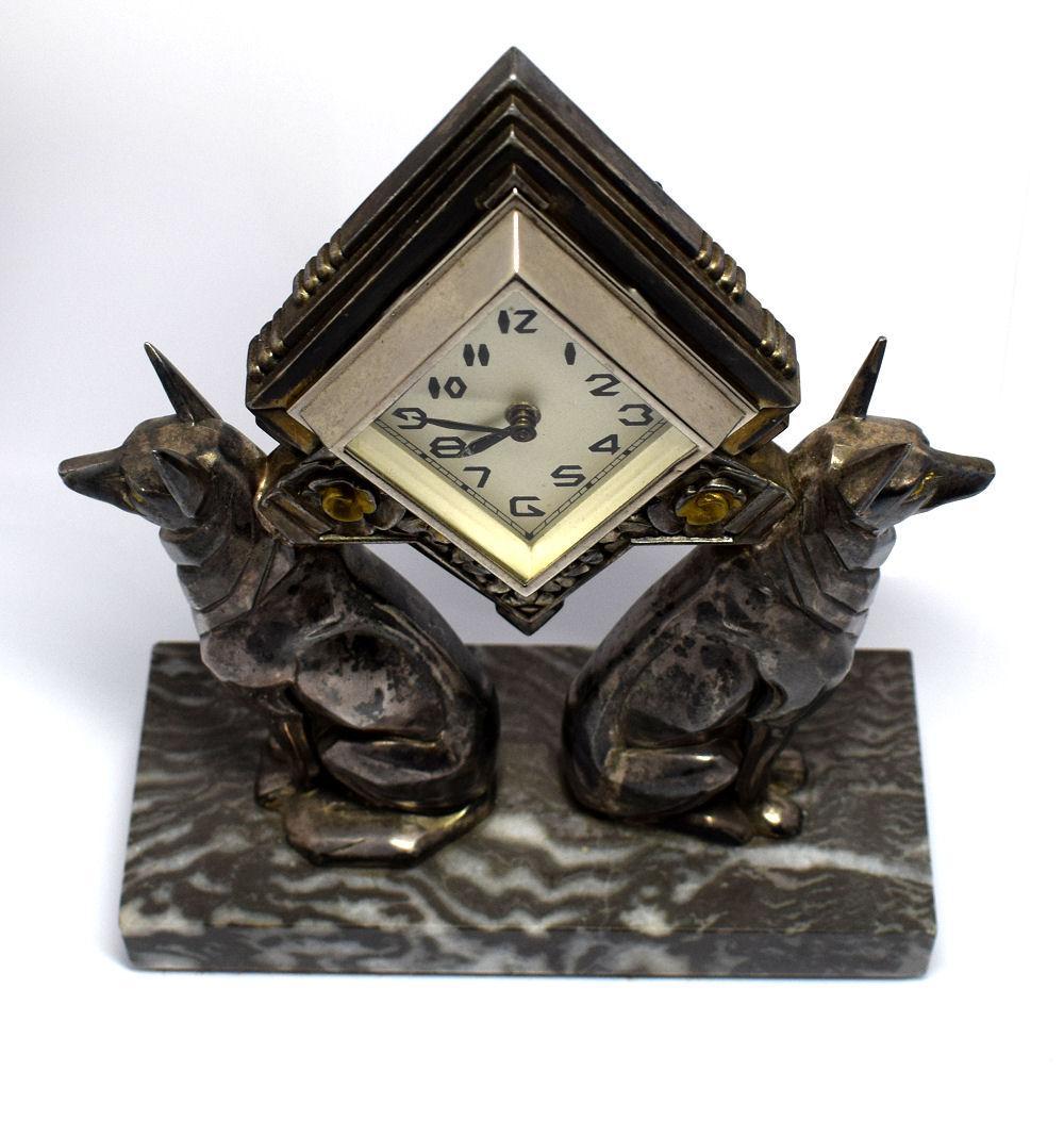 1930s Art Deco highly stylised Clock adorned by 2 Pharaoh dogs in pewter with silver plate which has some wear. Very attractive dial with Art Deco numerals. Solid double coloured marble base which is free from chips and damage. We've had this clock