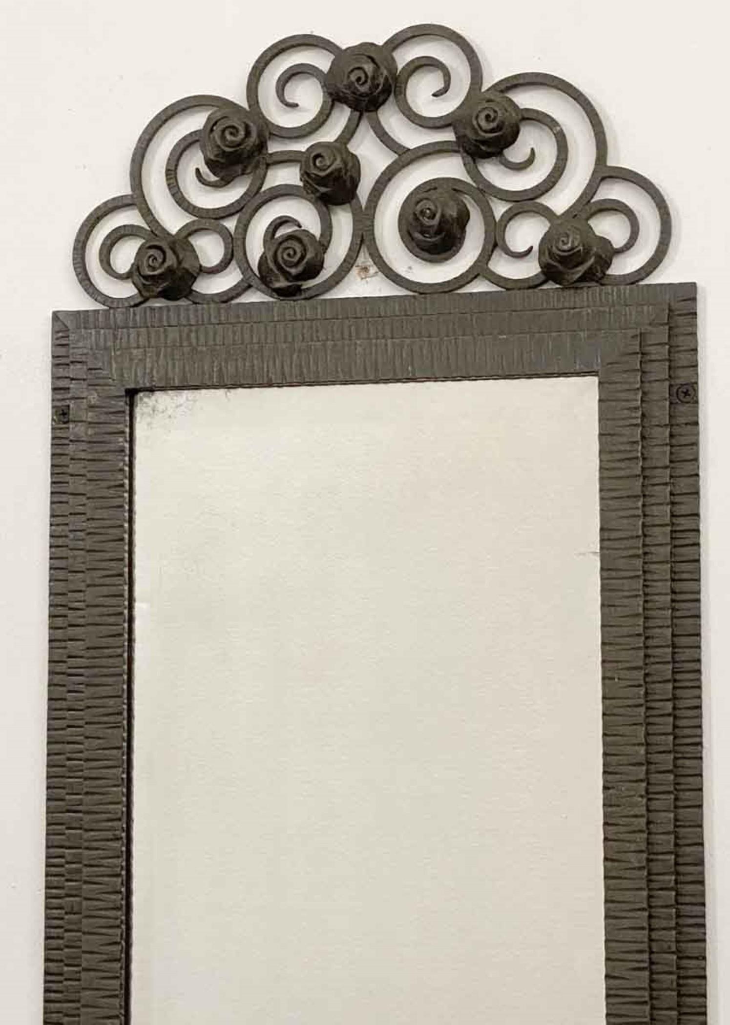 1930s French Art Deco beveled mirror in an original iron frame. Features floral top design. The original glass was resilvered and show signs of its age with some distressing and minor scratches. This can be seen at our 333 West 52nd St location in