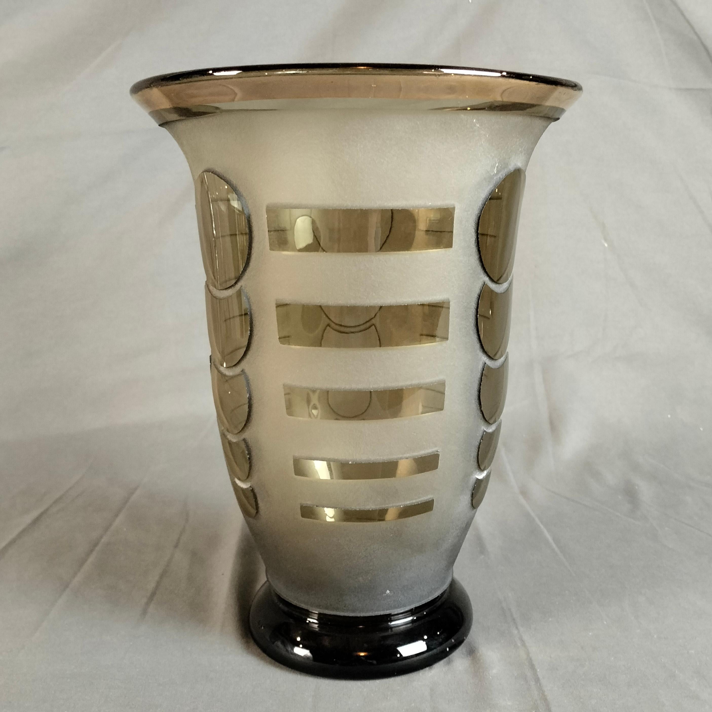 Jarrón de cristal ahumado arenado francés Art Decó de 1930, de Jean Luce.  Los diseños geométricos de rectángulos y círculos están marcados por el fondo arenado. El borde superior del jarrón muestra restos de su marca dorada original. 

Jean Luce