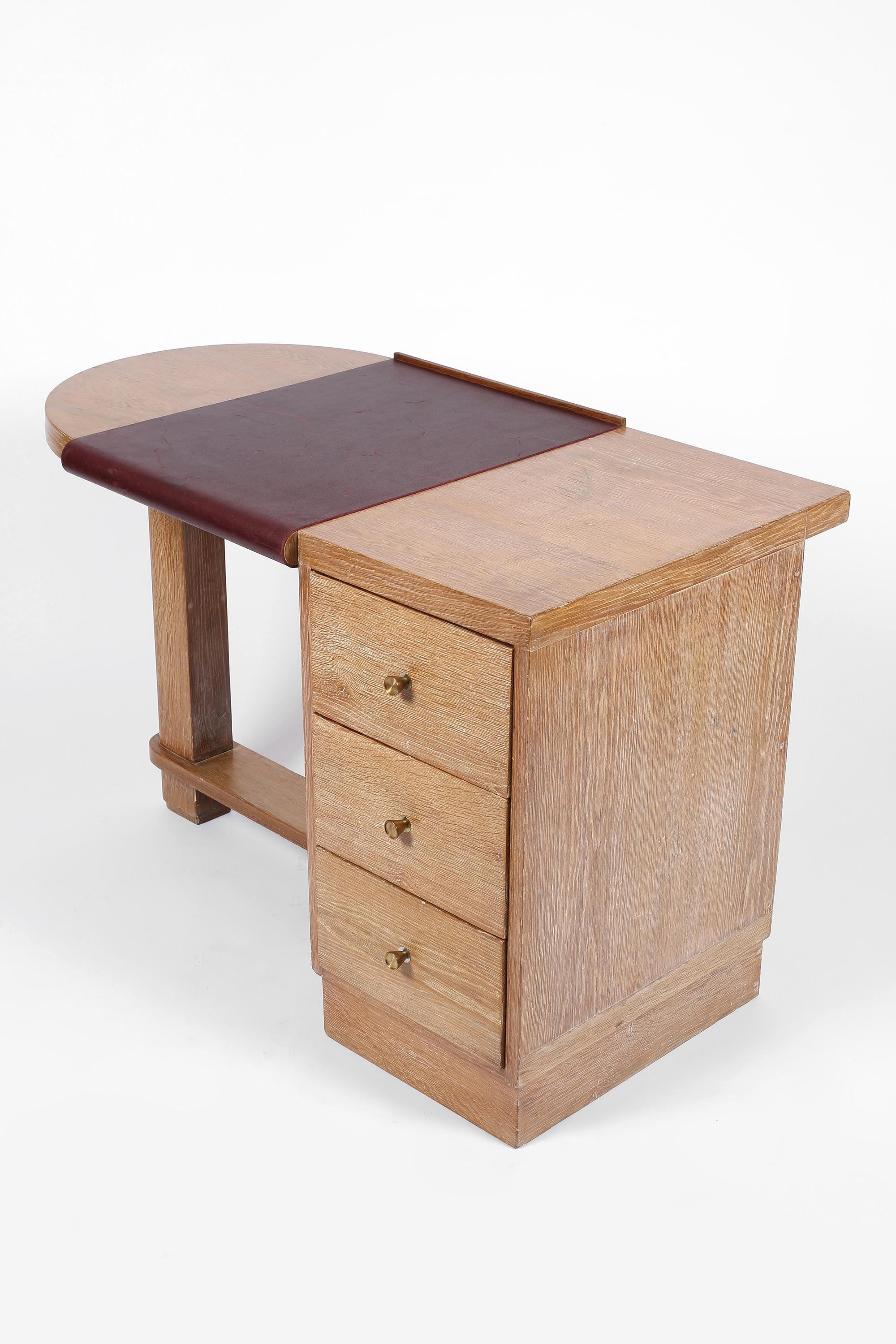 A modernist Art Deco desk in limed oak with partially clad oxblood leather top. With clean lines and simple brass drawer pulls, very much in the manner of Jacques Adnet or Eugene Printz. French, c. 1930s.

