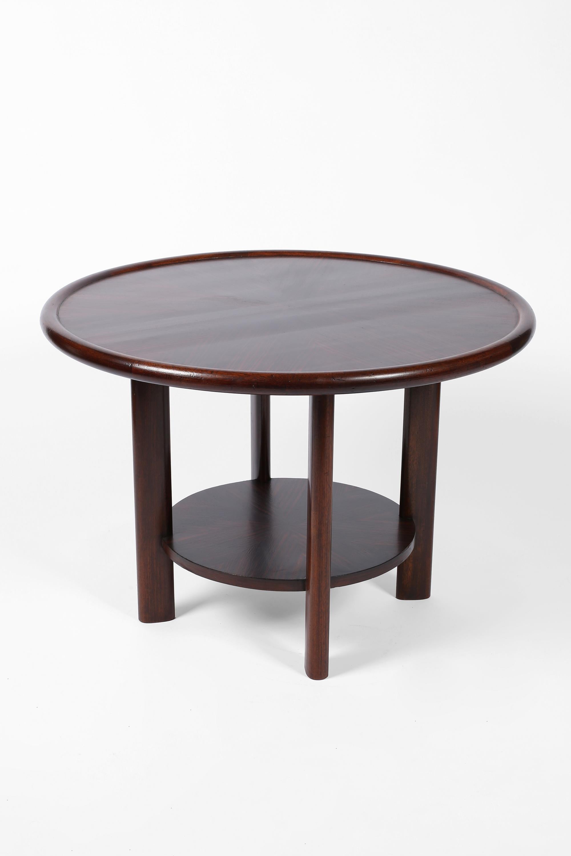 A circular Art Deco centre or large lamp table in solid mahogany with attractively veneered Macassar ebony top and lower tier. French, c. 1930s.