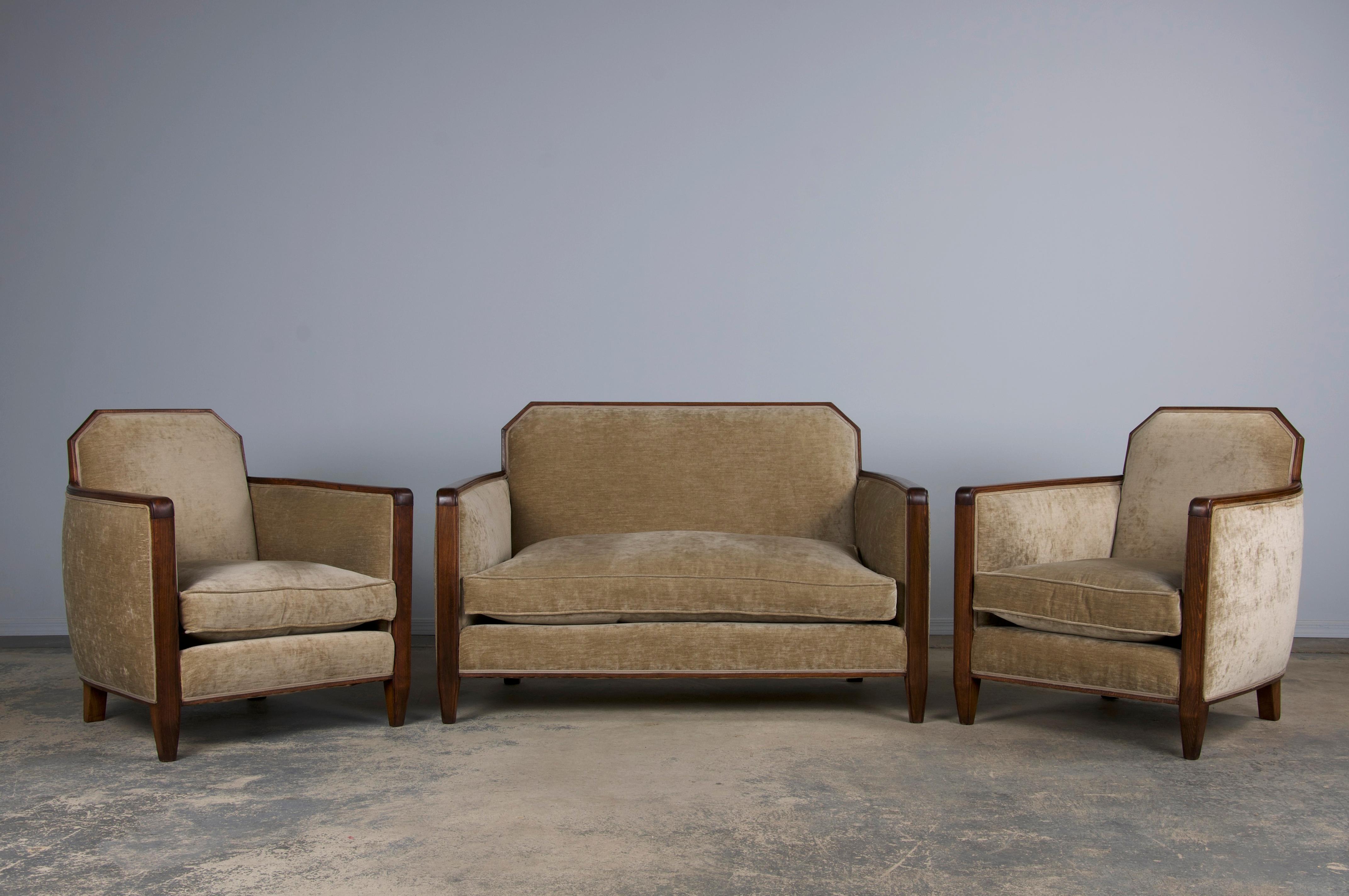 A traditional set of three 1930s French Art Deco club chairs and a matching loveseat, sourced directly from Provence, France. Expertly handcrafted from solid maple, each piece features striking square-shaped back frames with clean, angular lines.