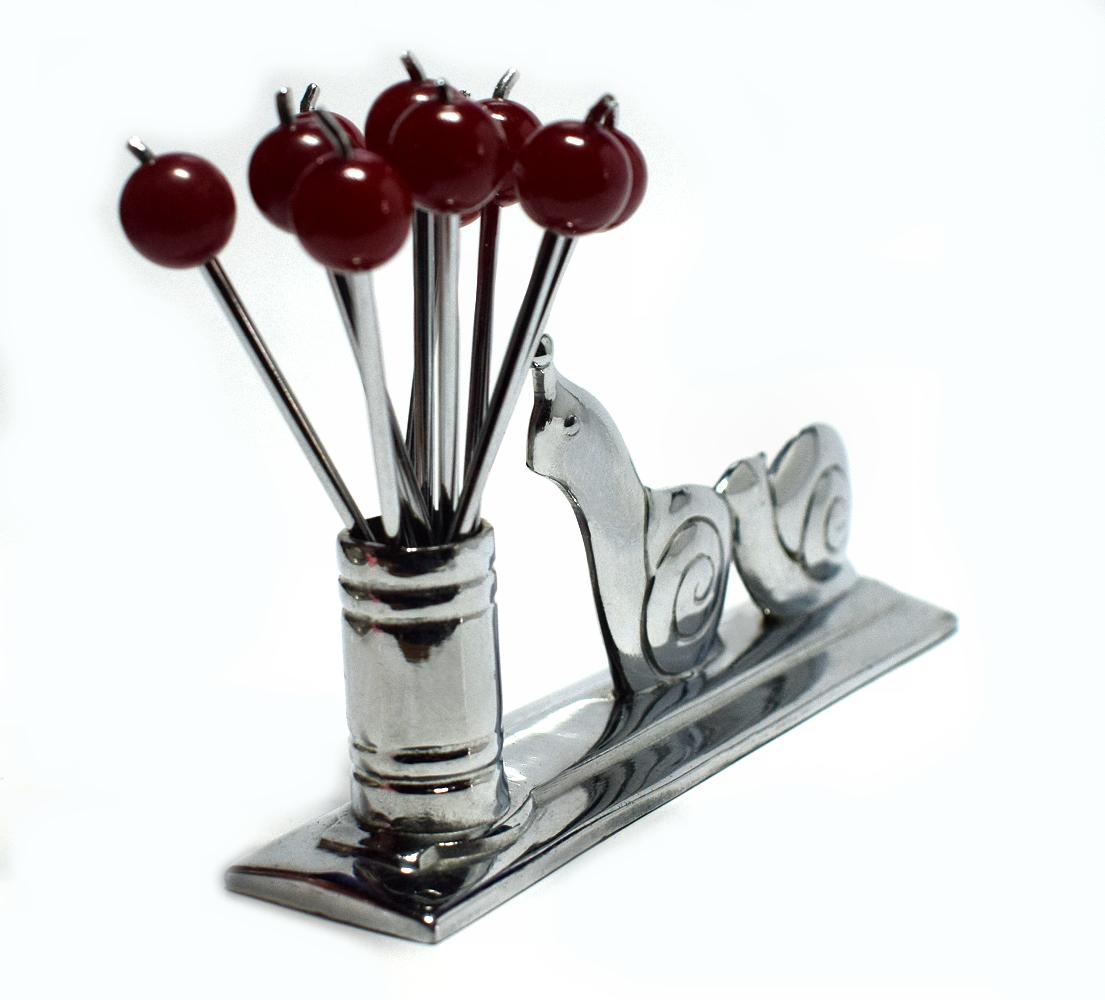 Very cute 1930s French Art Deco novelty chrome cocktail stick holder with chasing snails motif and red cherry Bakelite and chrome cocktail sticks. The chrome throughout is in excellent condition as is the Bakelite.