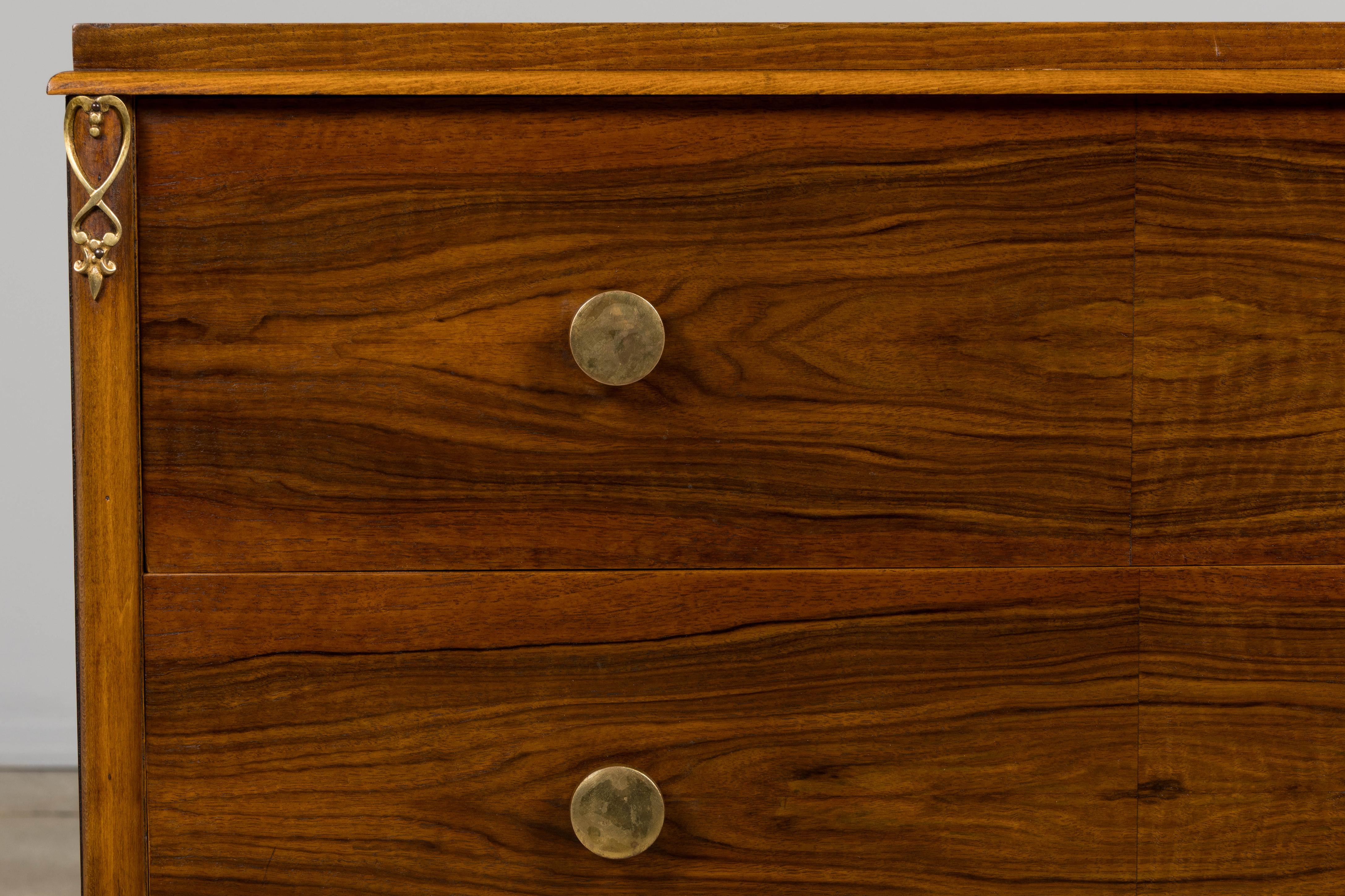 Cómoda francesa Art Decó de nogal, de los años 30, procedente de la Provenza francesa. La forma rectangular presenta tres cajones chapados en nogal de ricas figuras, creando audaces patrones de veteado simétricos. Cada cajón lleva tiradores redondos