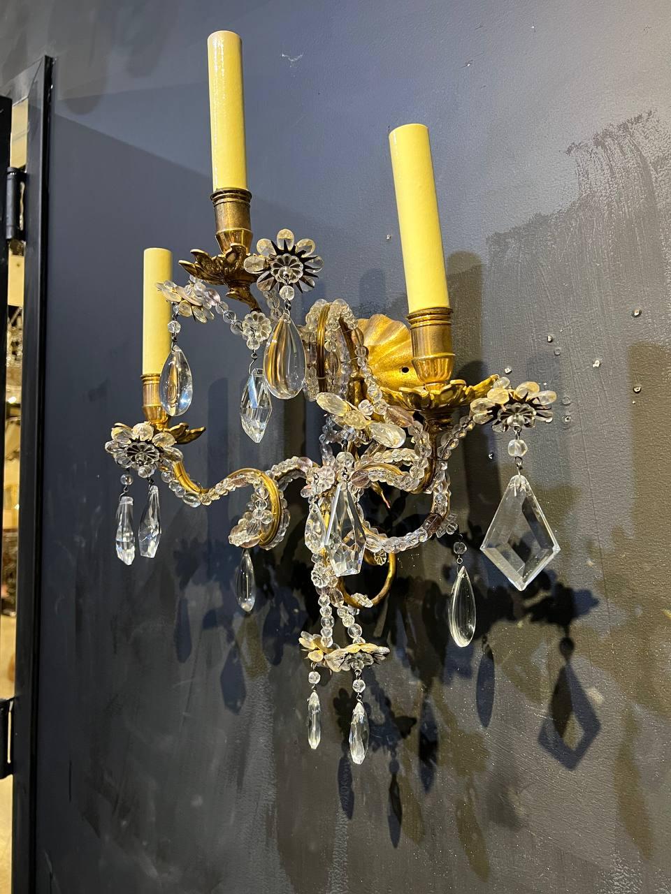 A pair of circa 1930's French Bagues sconces with three scroll arms and beaded crystals and hanging crystals