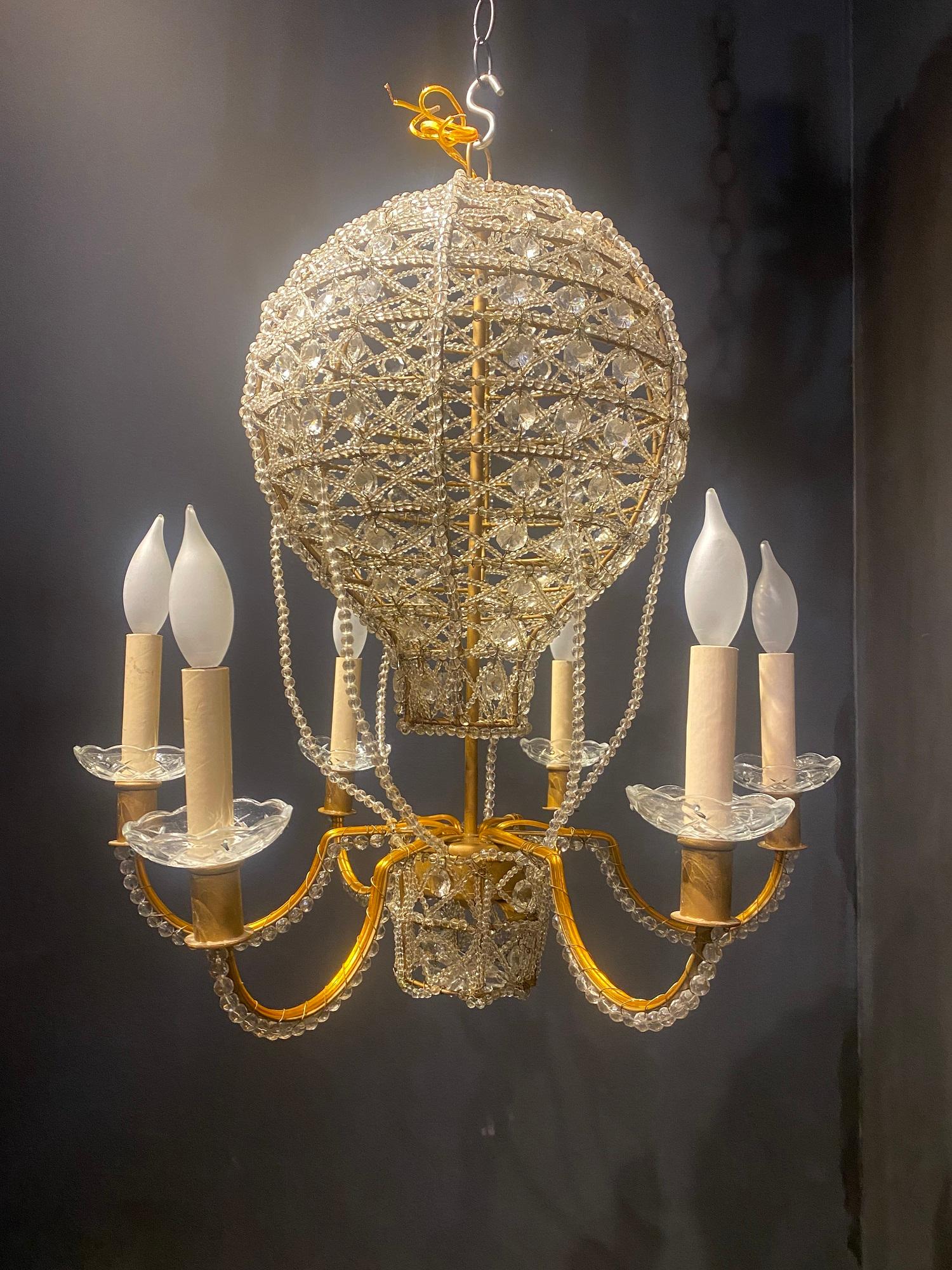 A circa 1930’s French gilt metal chandelier with beaded crystals, balloon shape and design