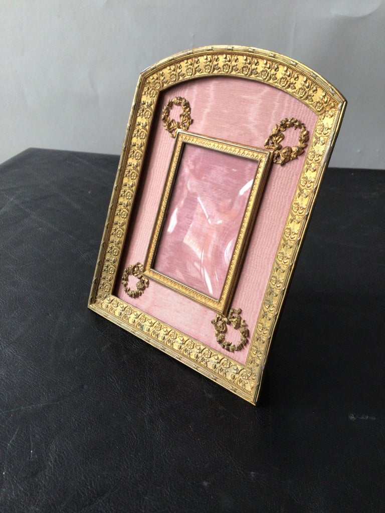 1930s French brass frame adorned with wreaths. Measures: 2.5 x 3.5.