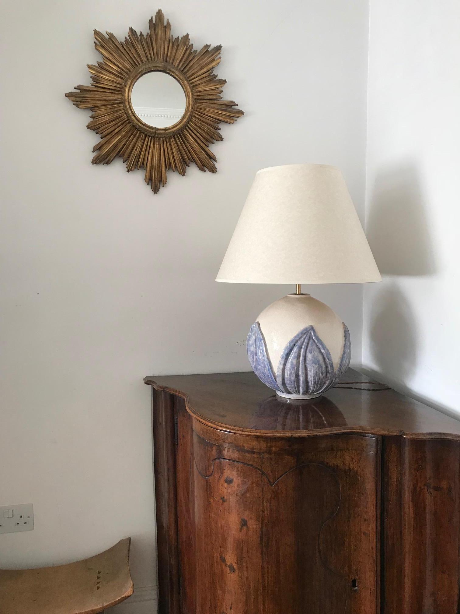 A large crackle glazed, French, 1930s spherical globe lamp signed Wibaux. Decorated with blue relief lotus leaves. A beautiful example of early French art deco design. There is a surface crack to the rim on the base of the lamp, but this is